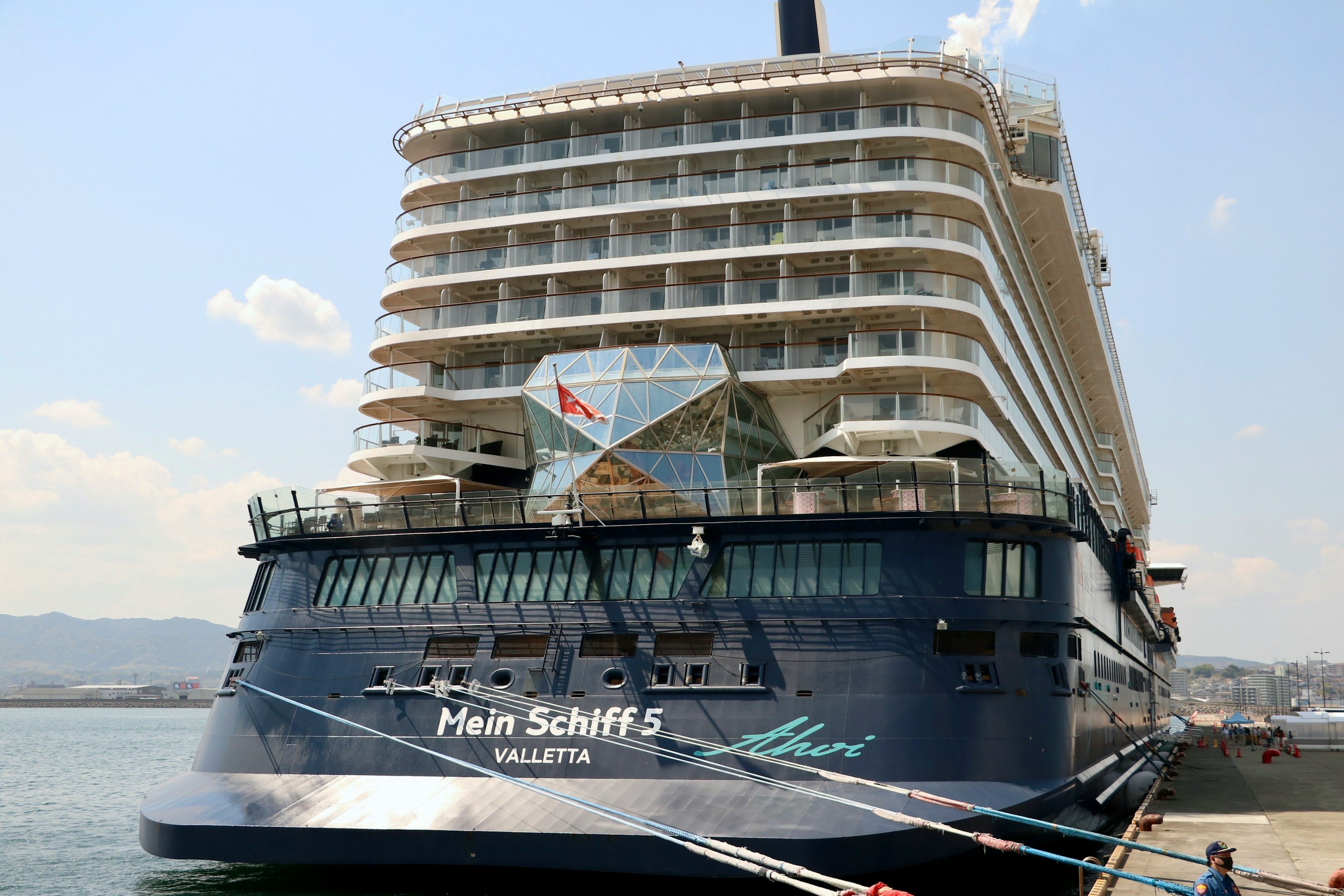 Vista lateral del crucero de lujo Mein Schiff 5 con paisaje portuario