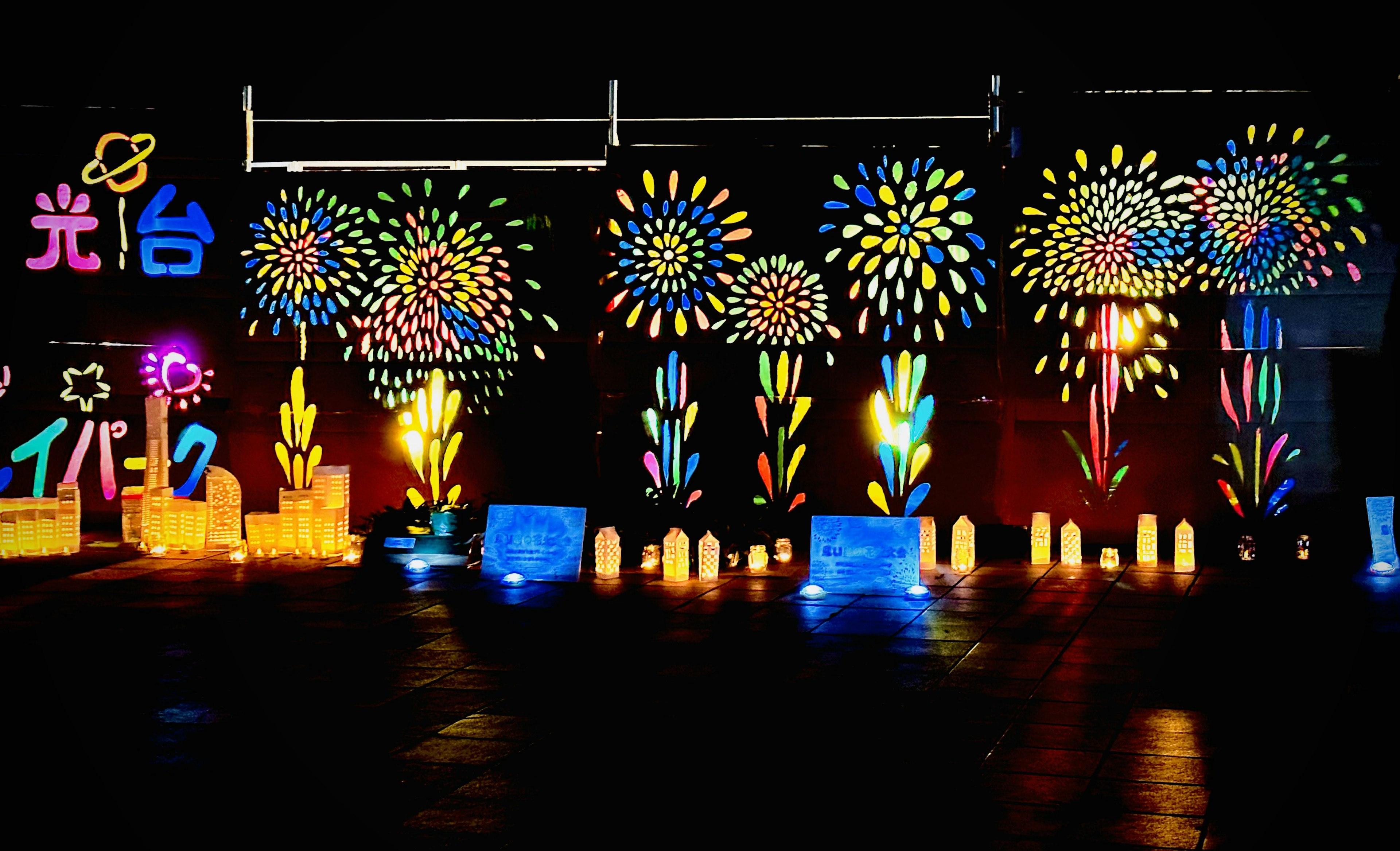 Bunte Lichtdekorationen mit Feuerwerksmotiven an einer Wand