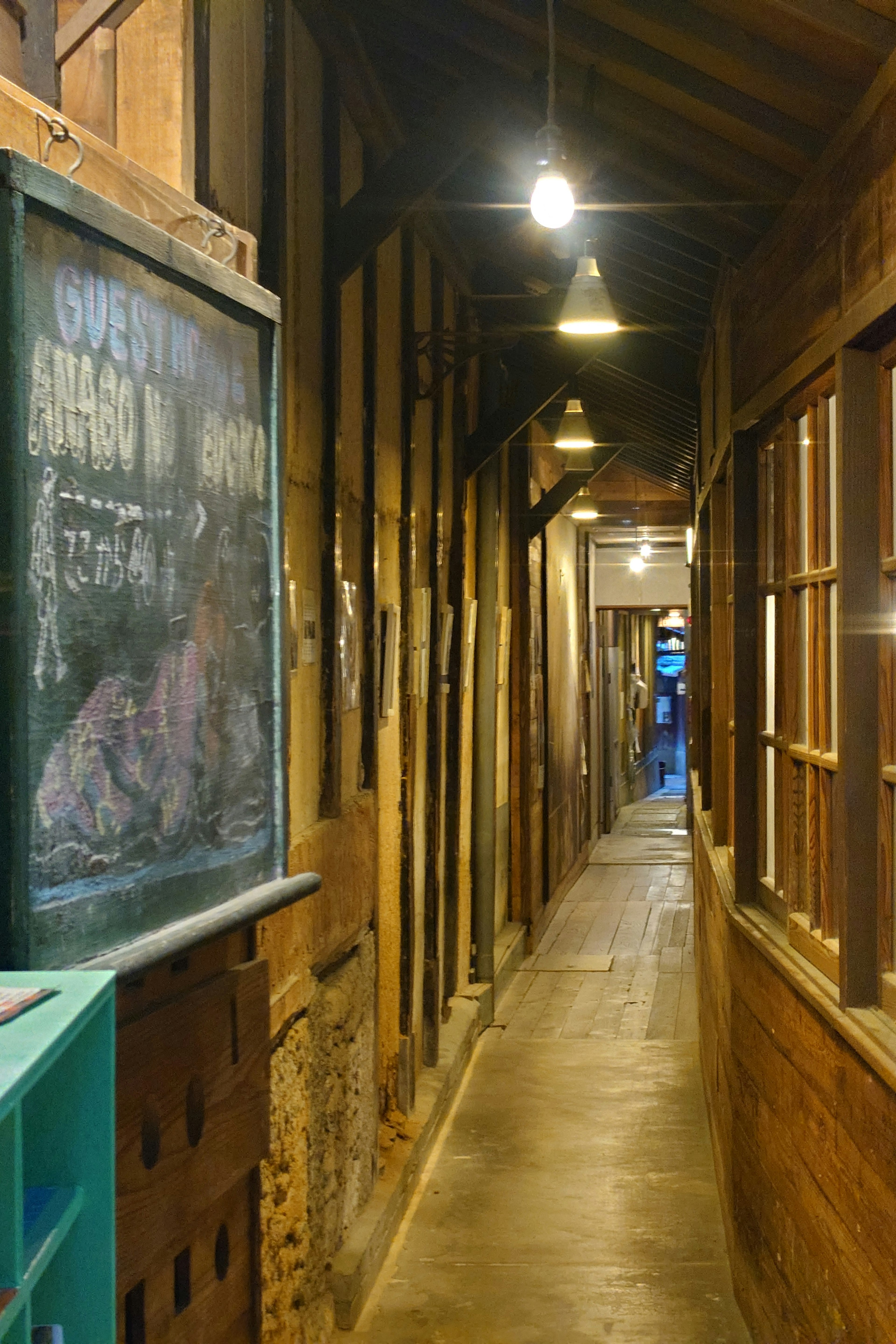 Narrow hallway with wooden walls and old windows