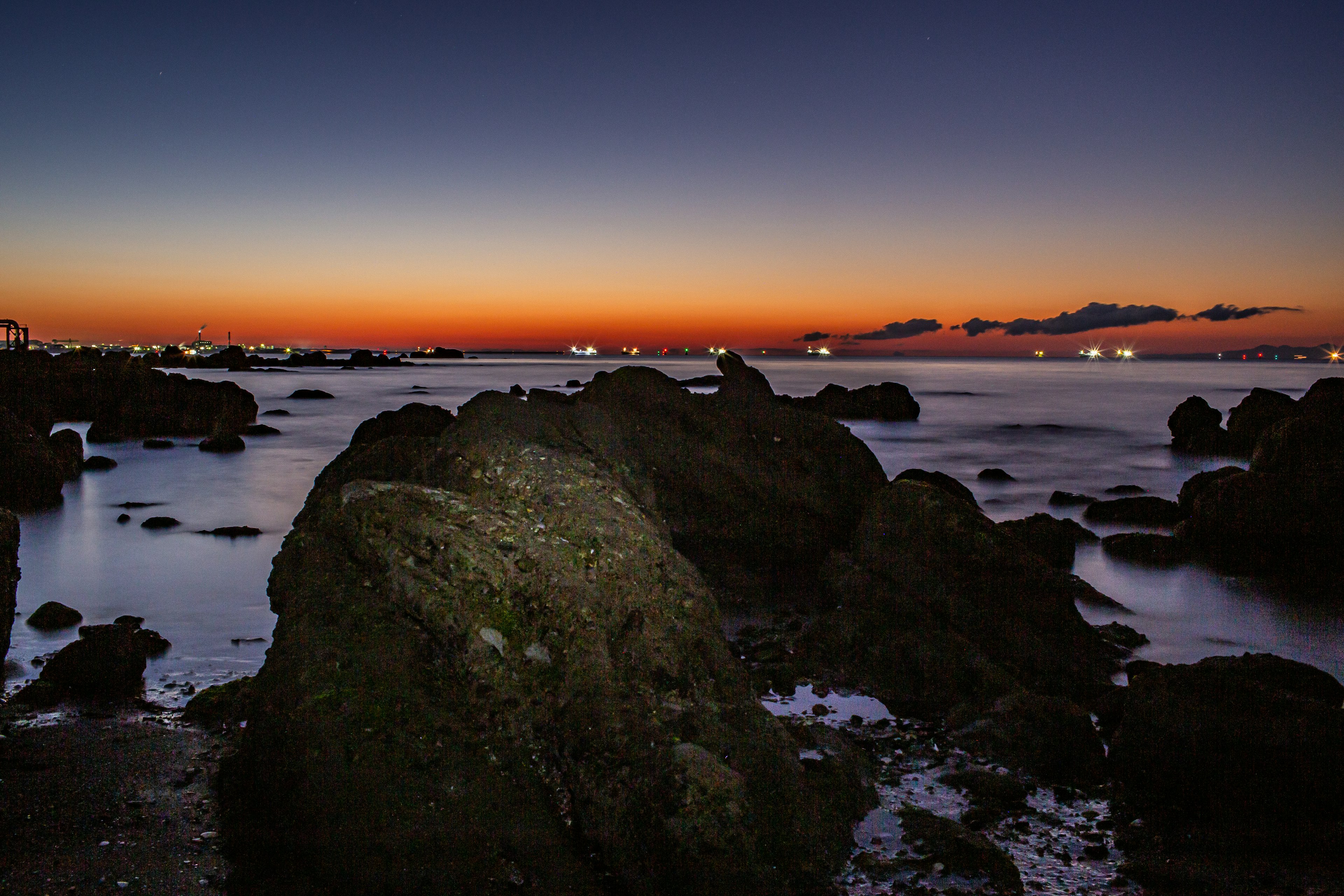 Scenic view of rocky coastline at sunset