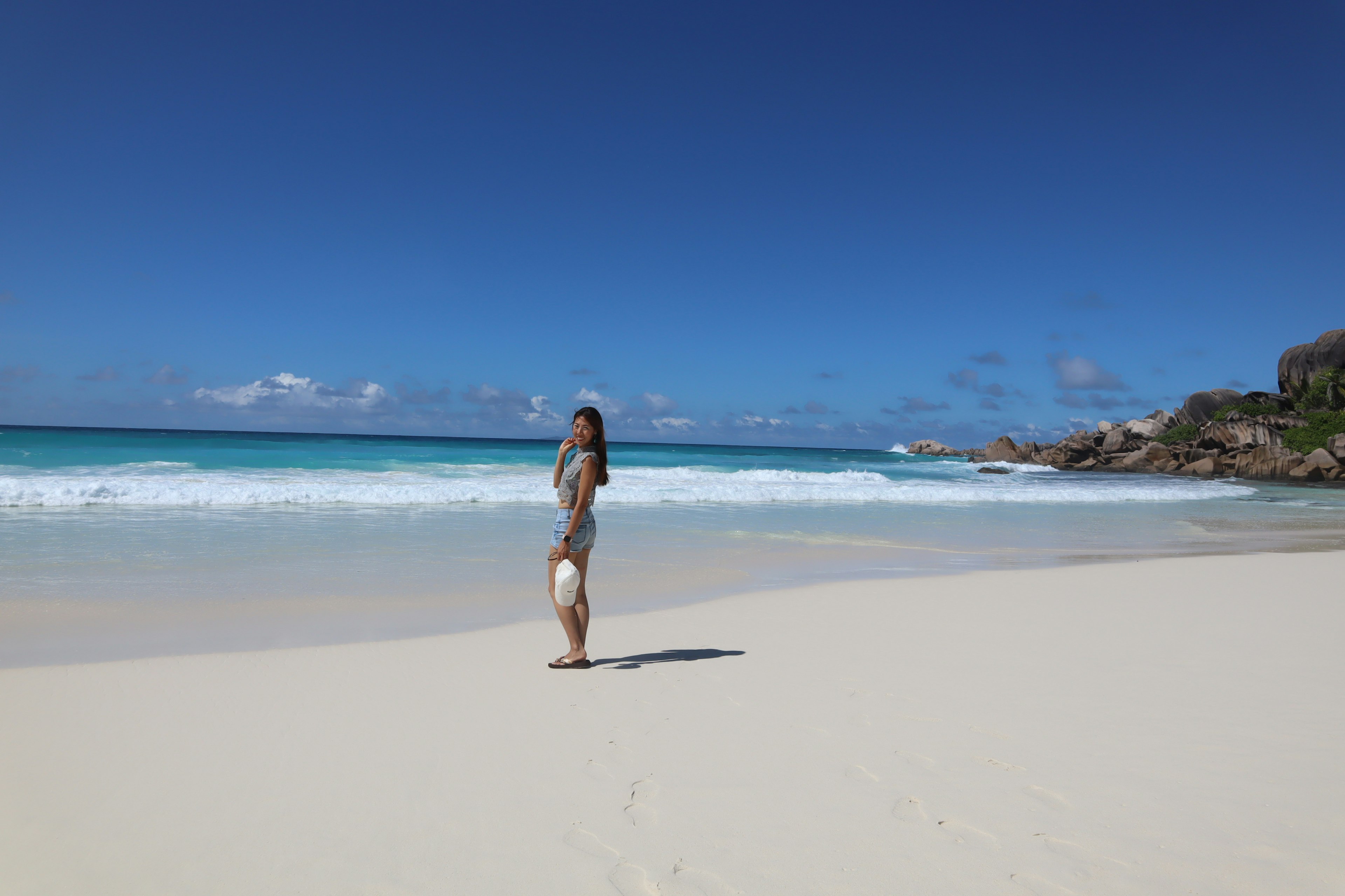 Eine Frau steht am Strand mit einem blauen Ozean