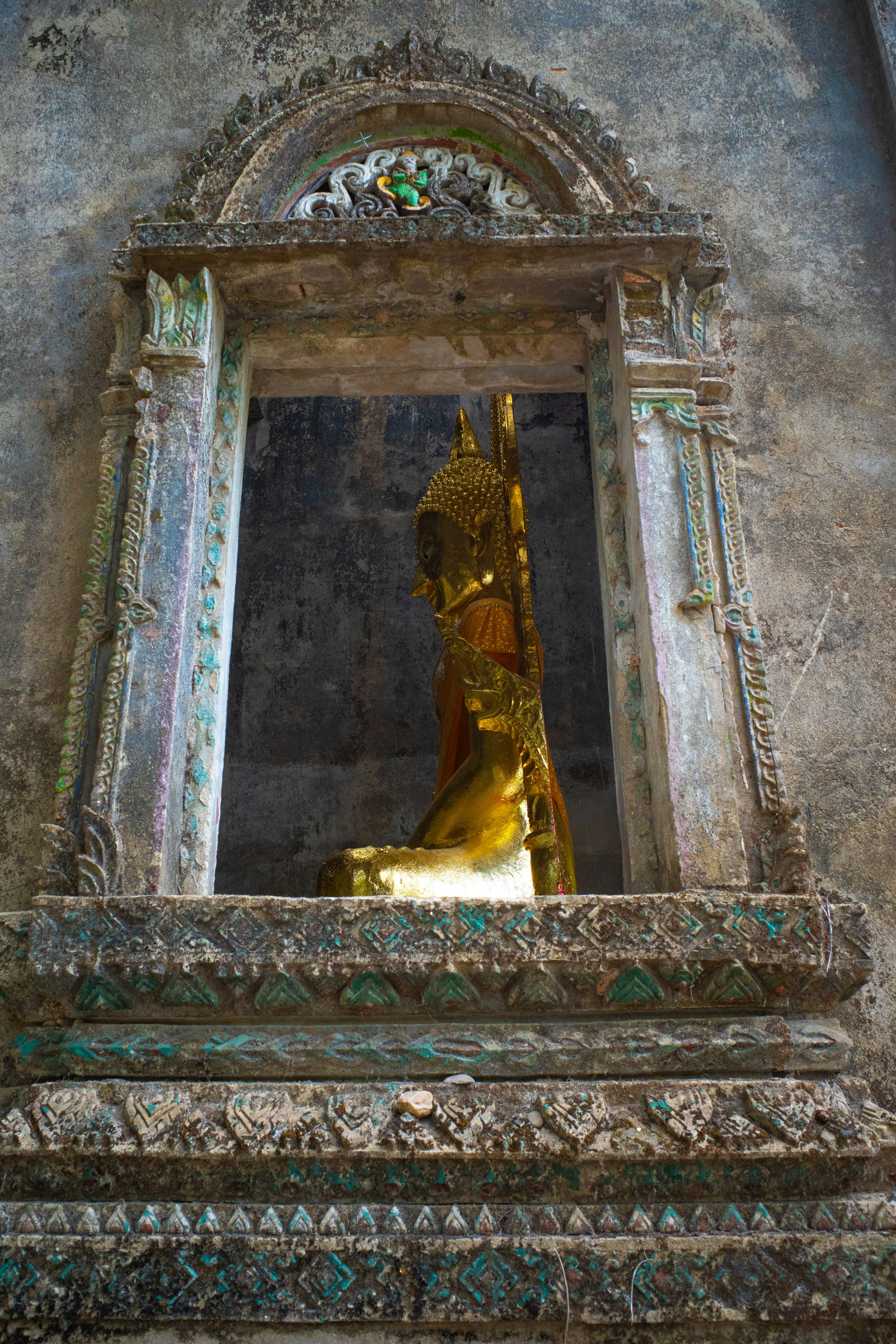 Estatua de Buda dorada en un nicho de un antiguo templo