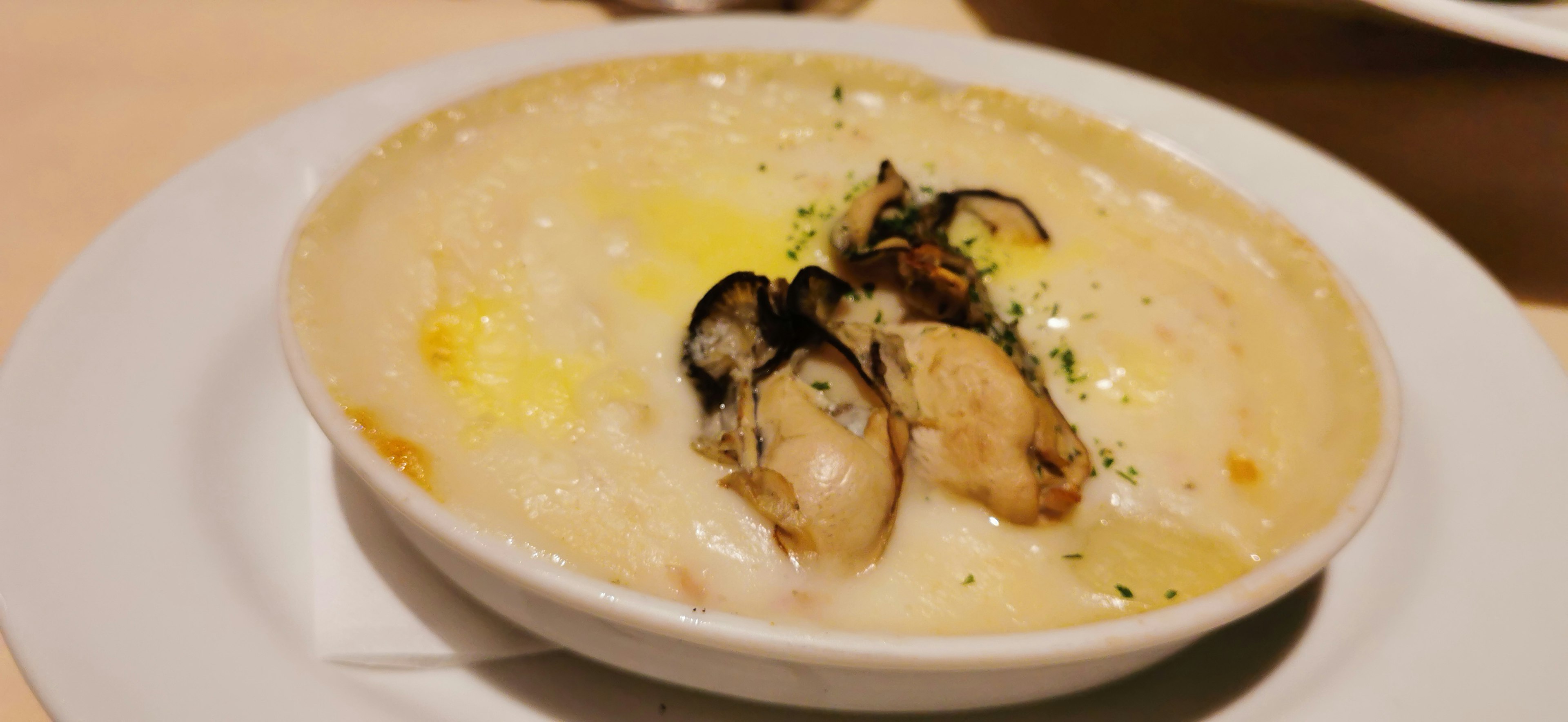 Creamy risotto topped with mussels served in a white bowl