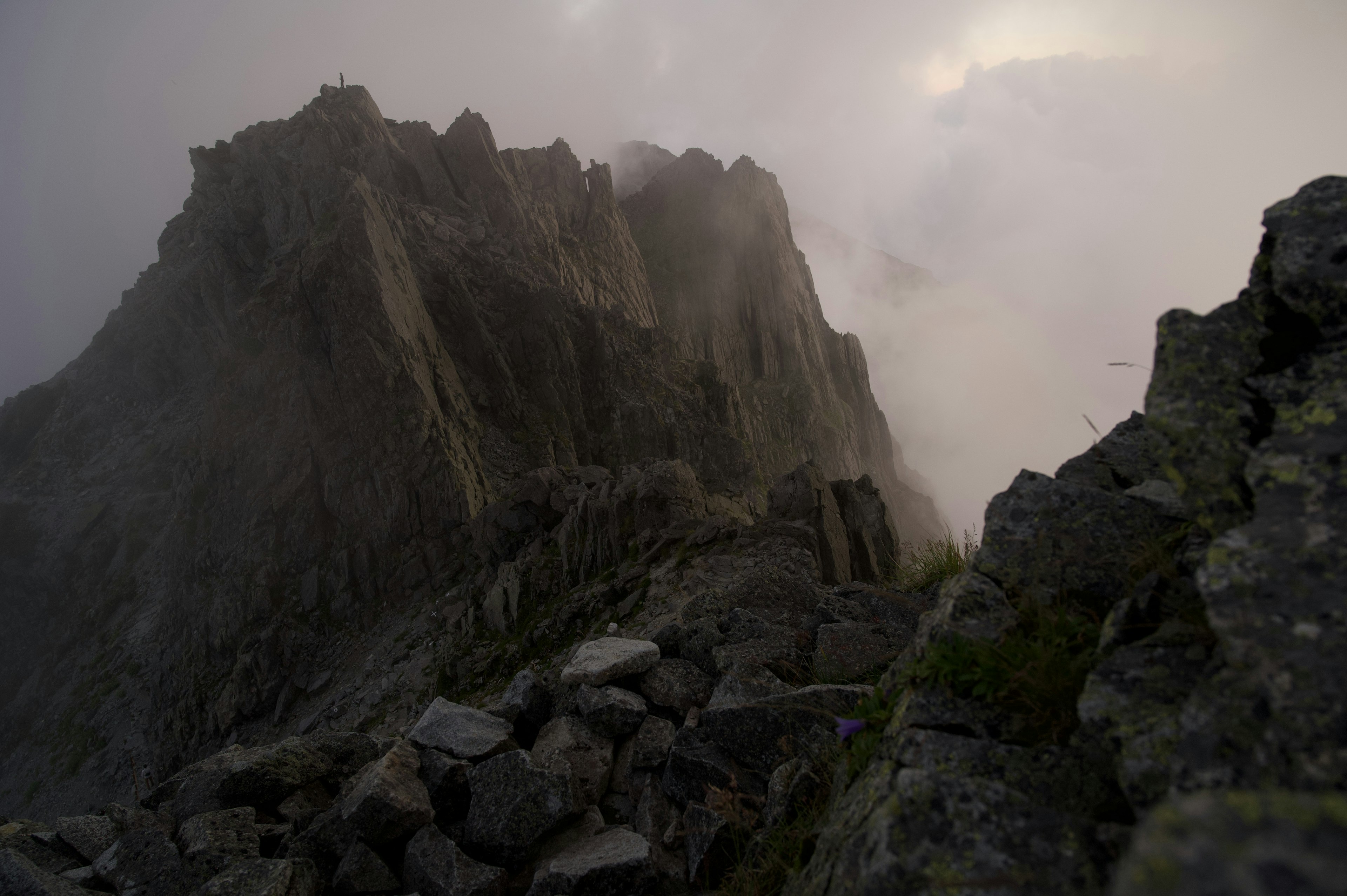 Mountain peak shrouded in mist with rocky terrain