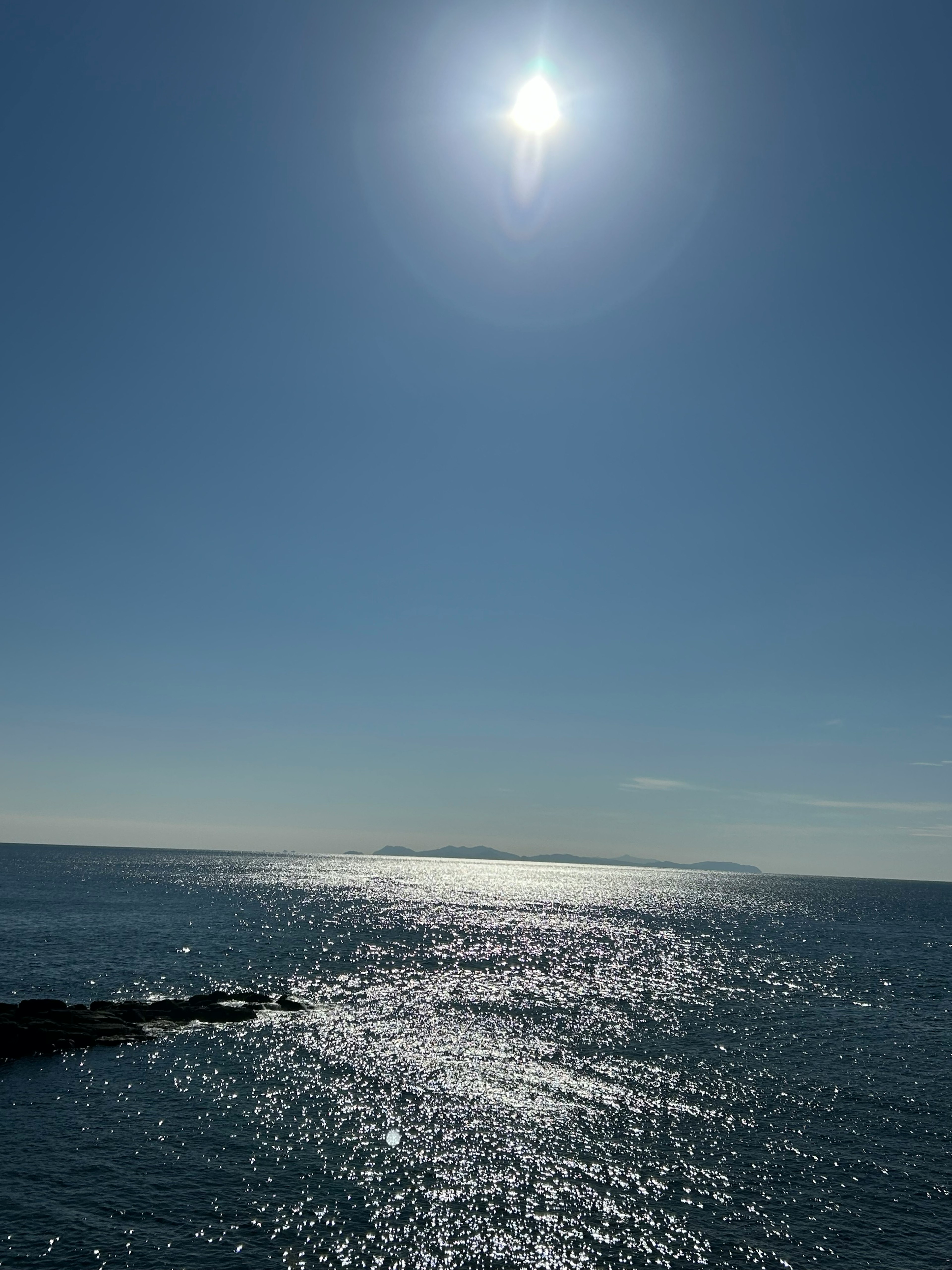 Ein hellblaues Meer mit der Sonne, die auf das Wasser reflektiert