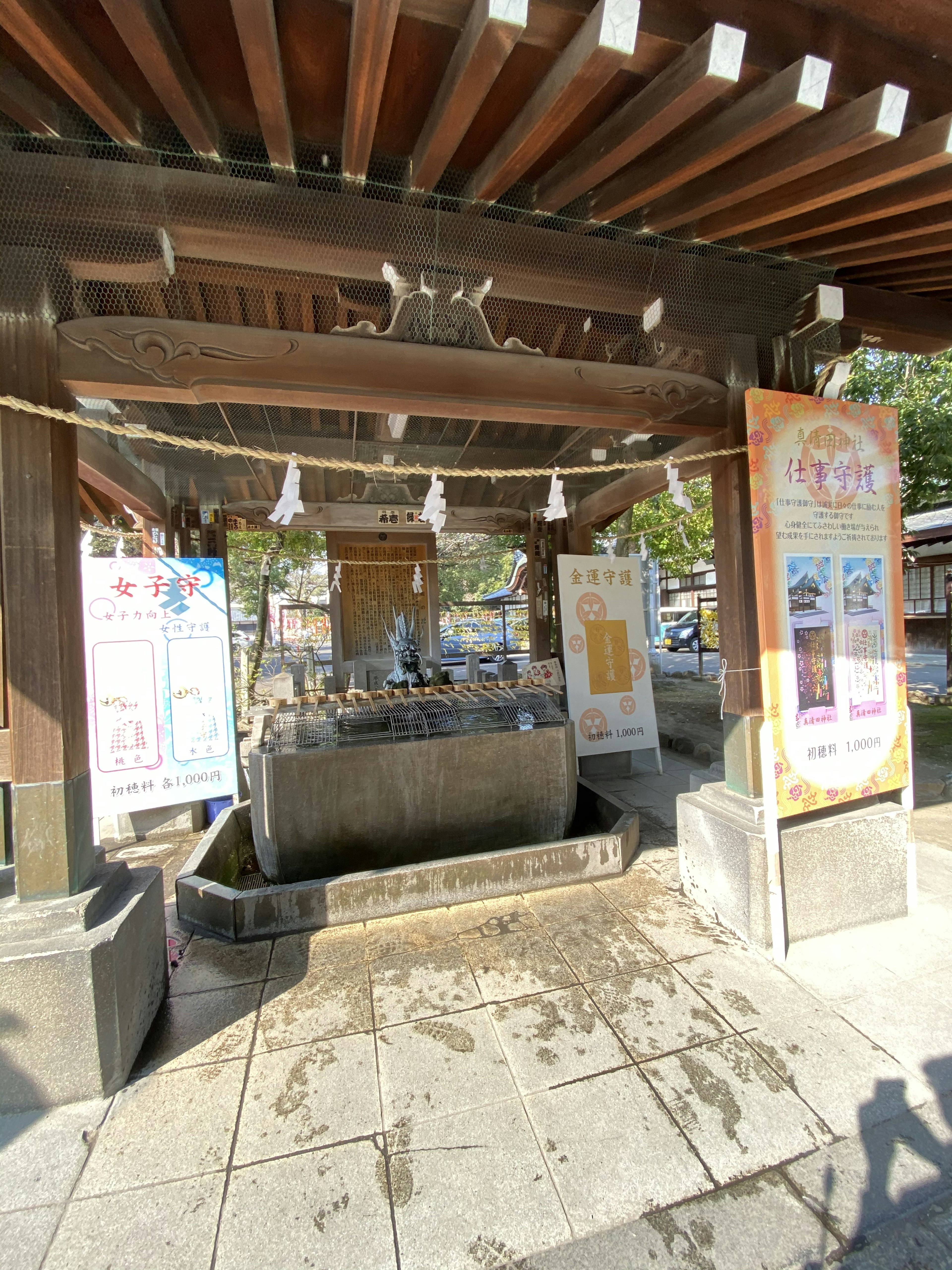 Purification water basin at a shrine with signage and wooden structure