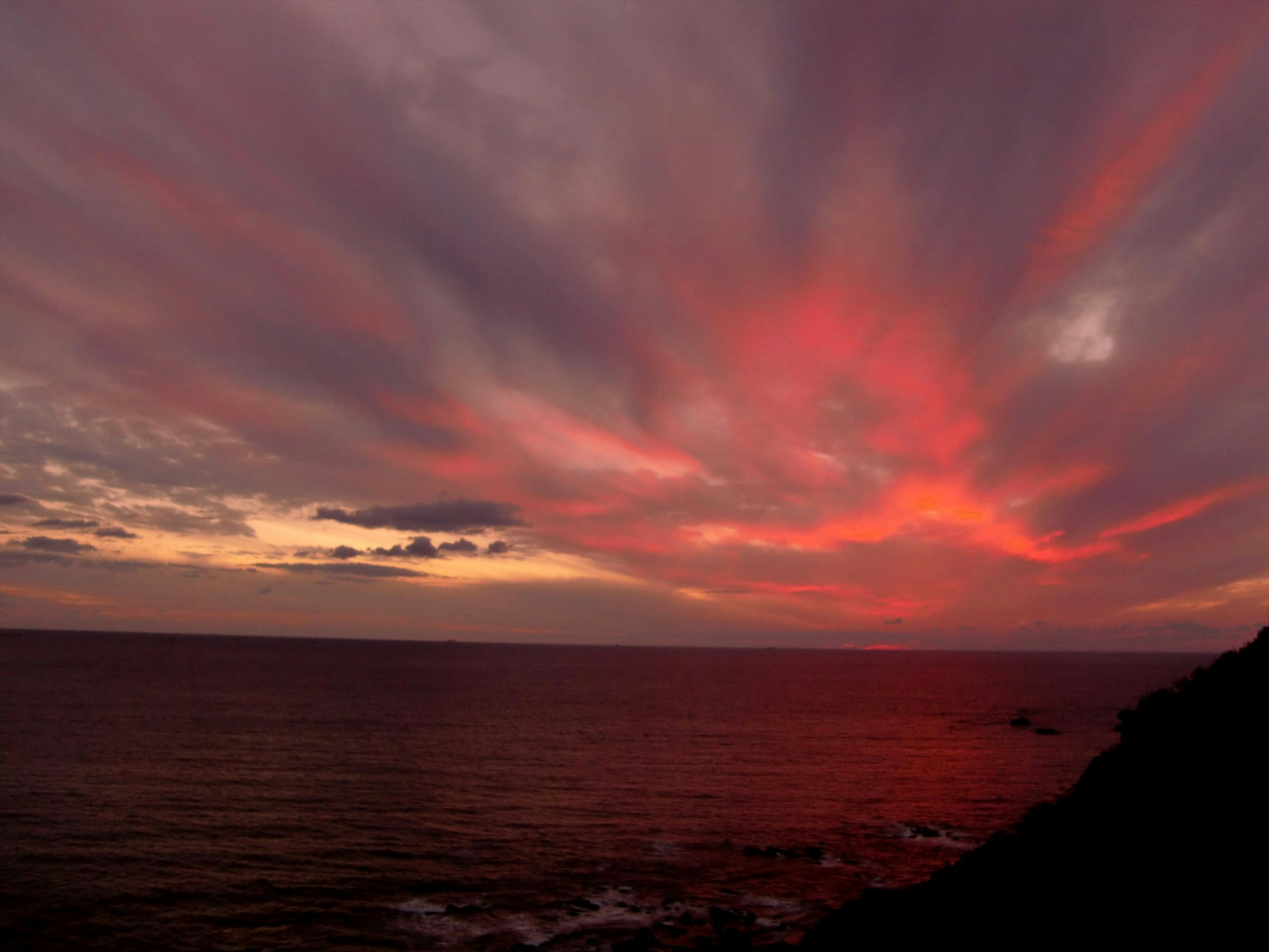 赤い夕焼けの空が海に映る風景