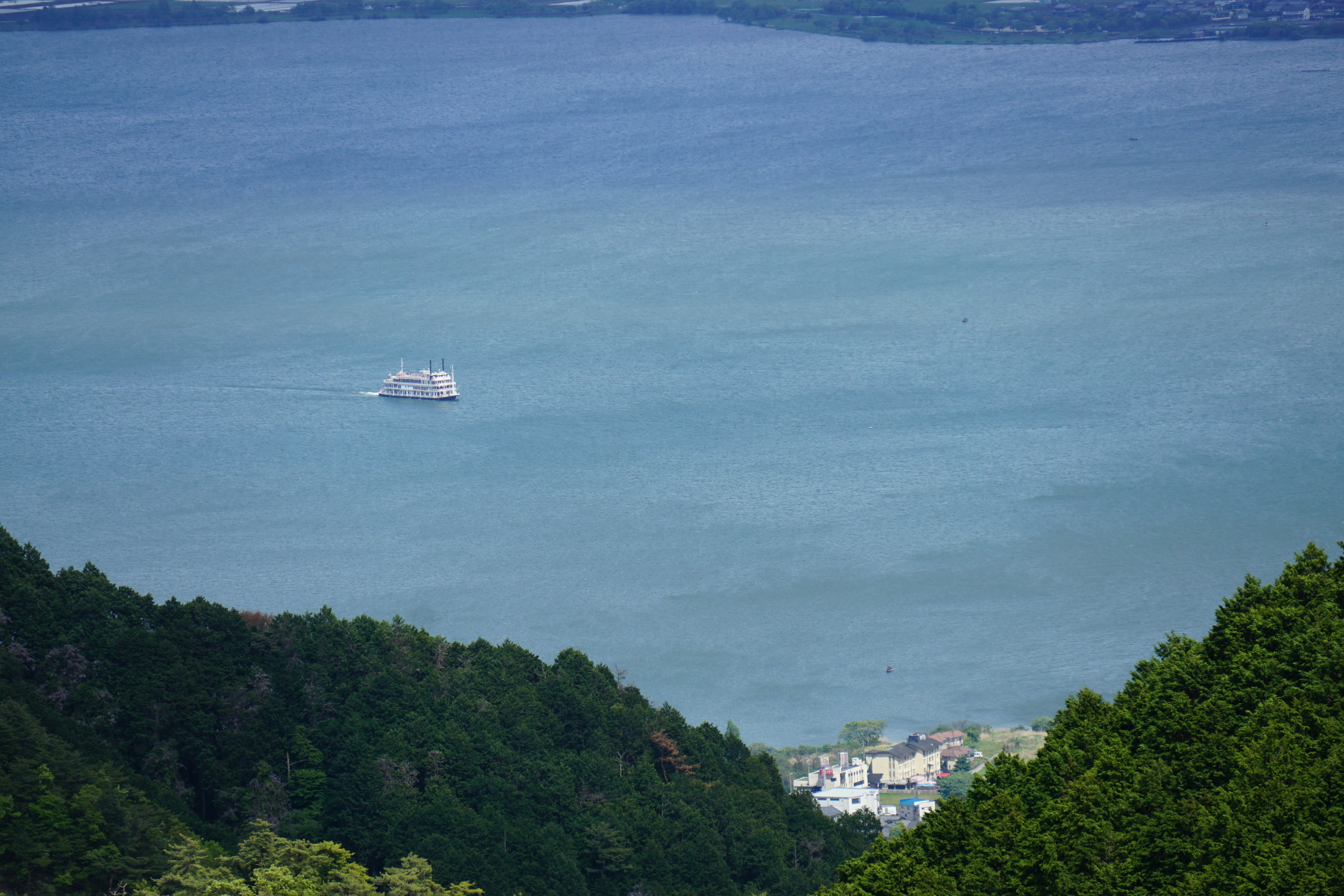 Panoramablick auf das blaue Meer und die Berge mit einer kleinen Insel und einem Dorf