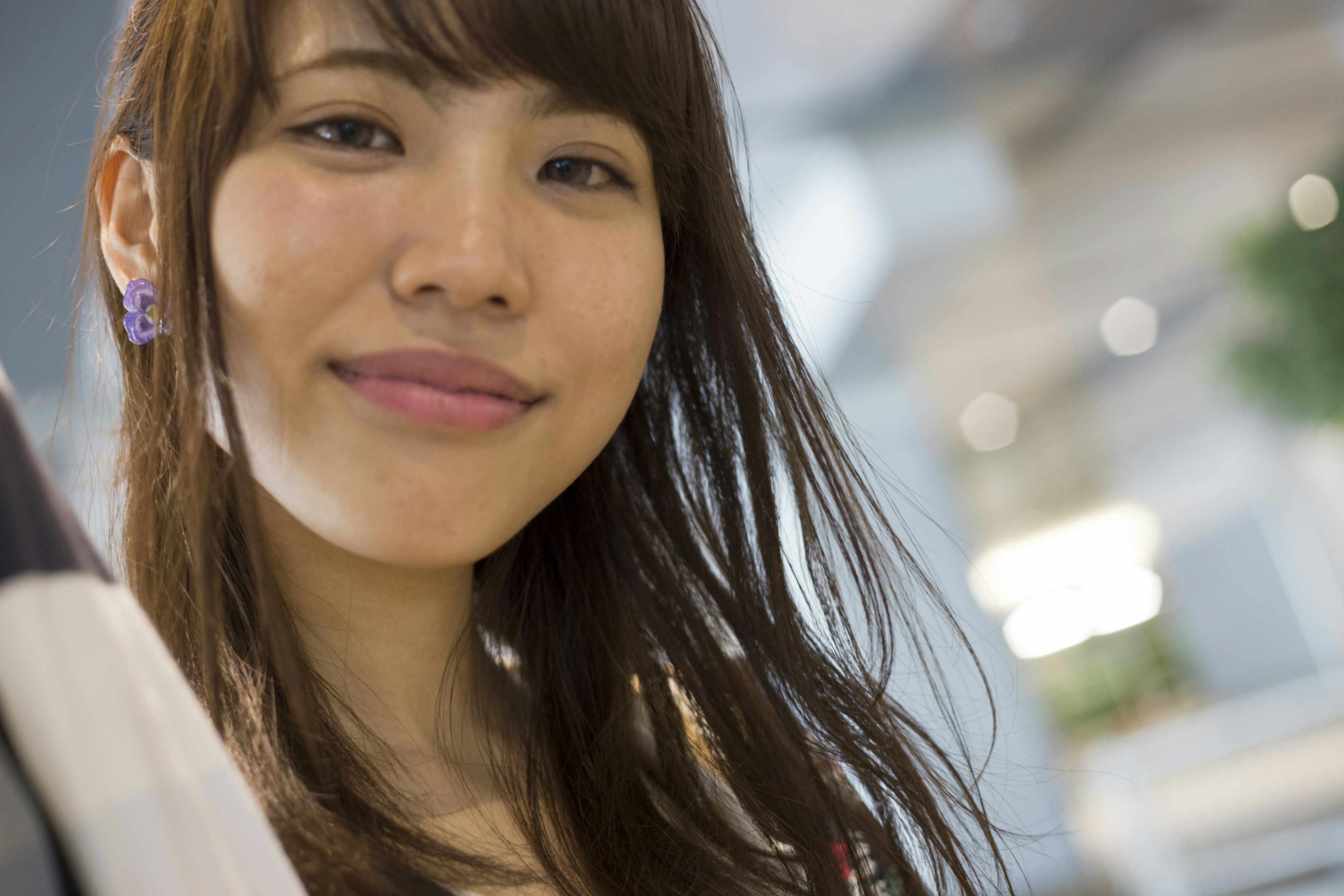 Portrait d'une femme souriante avec de longs cheveux dans un fond lumineux