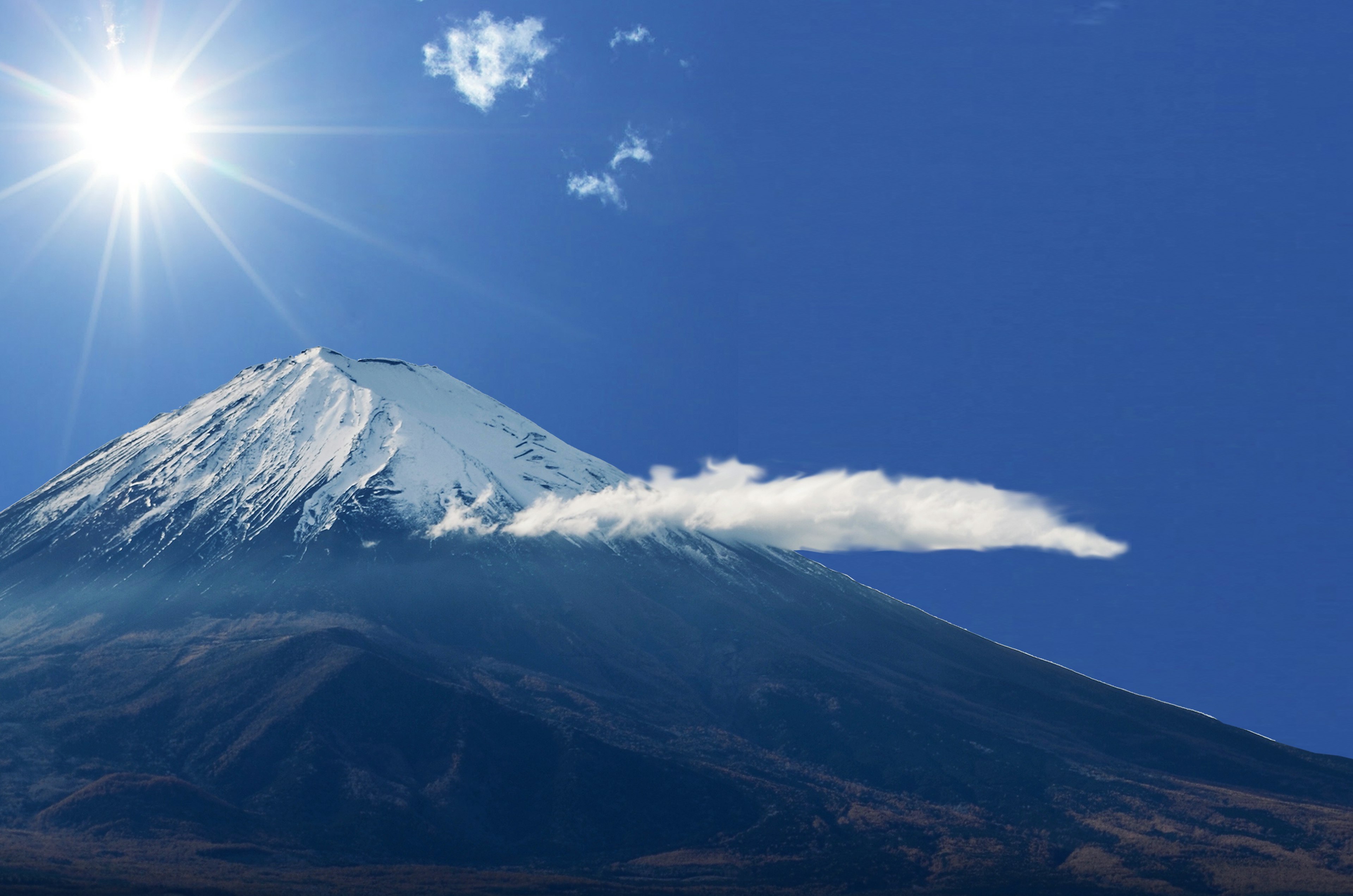 青空の下にそびえる富士山の美しい姿と輝く太陽