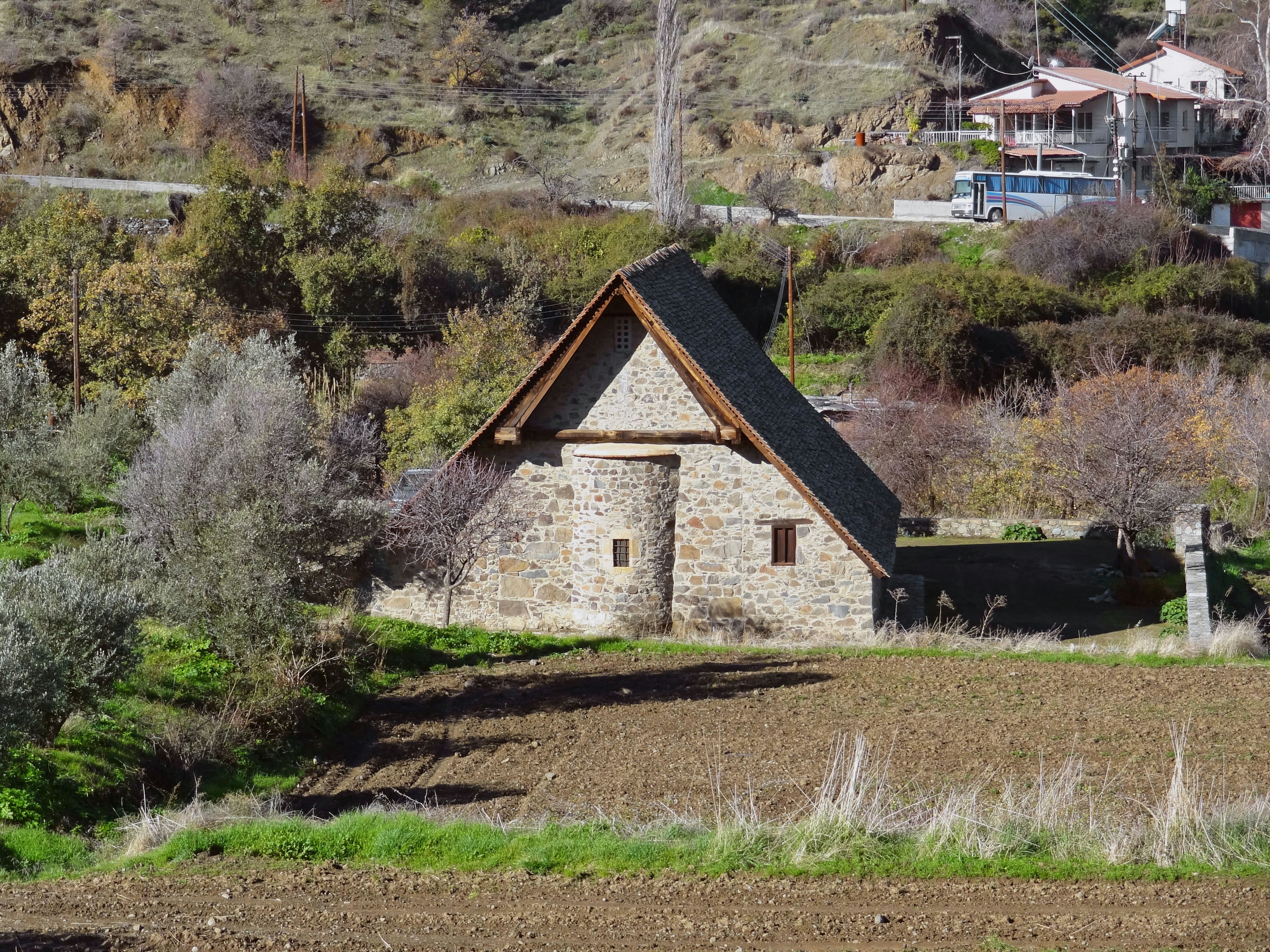 Cabaña de piedra rodeada de vegetación en un paisaje rural