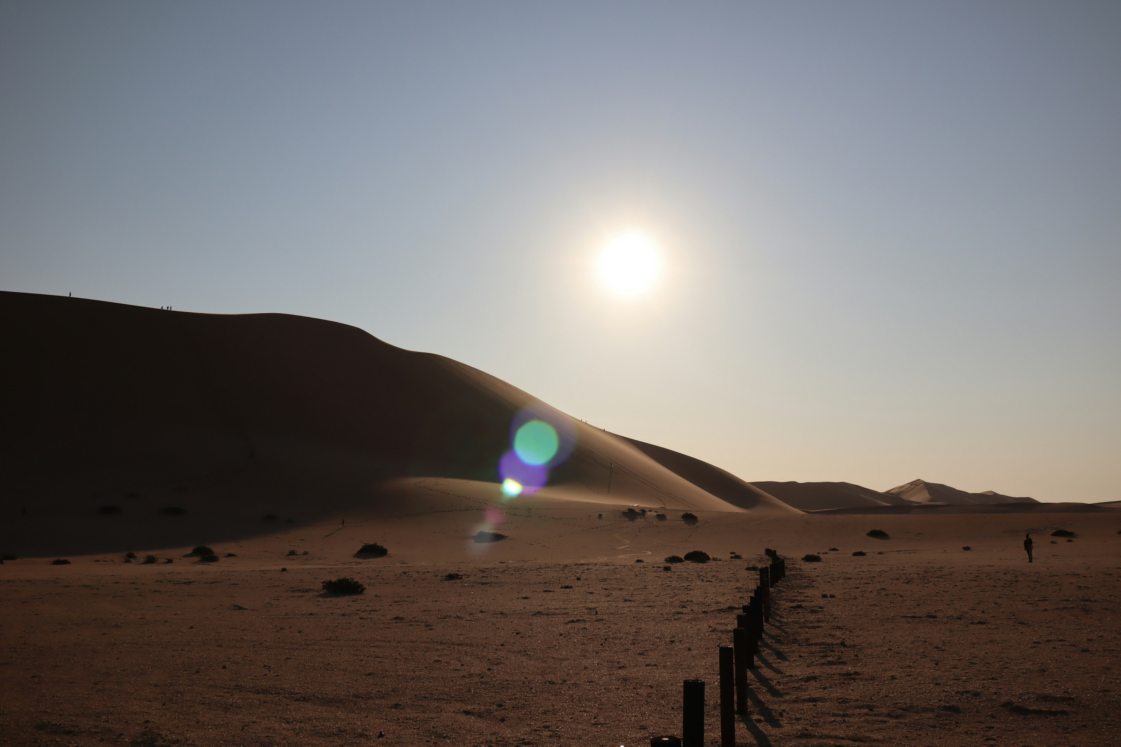 Paesaggio desertico con sole al tramonto e dune di sabbia in ombra