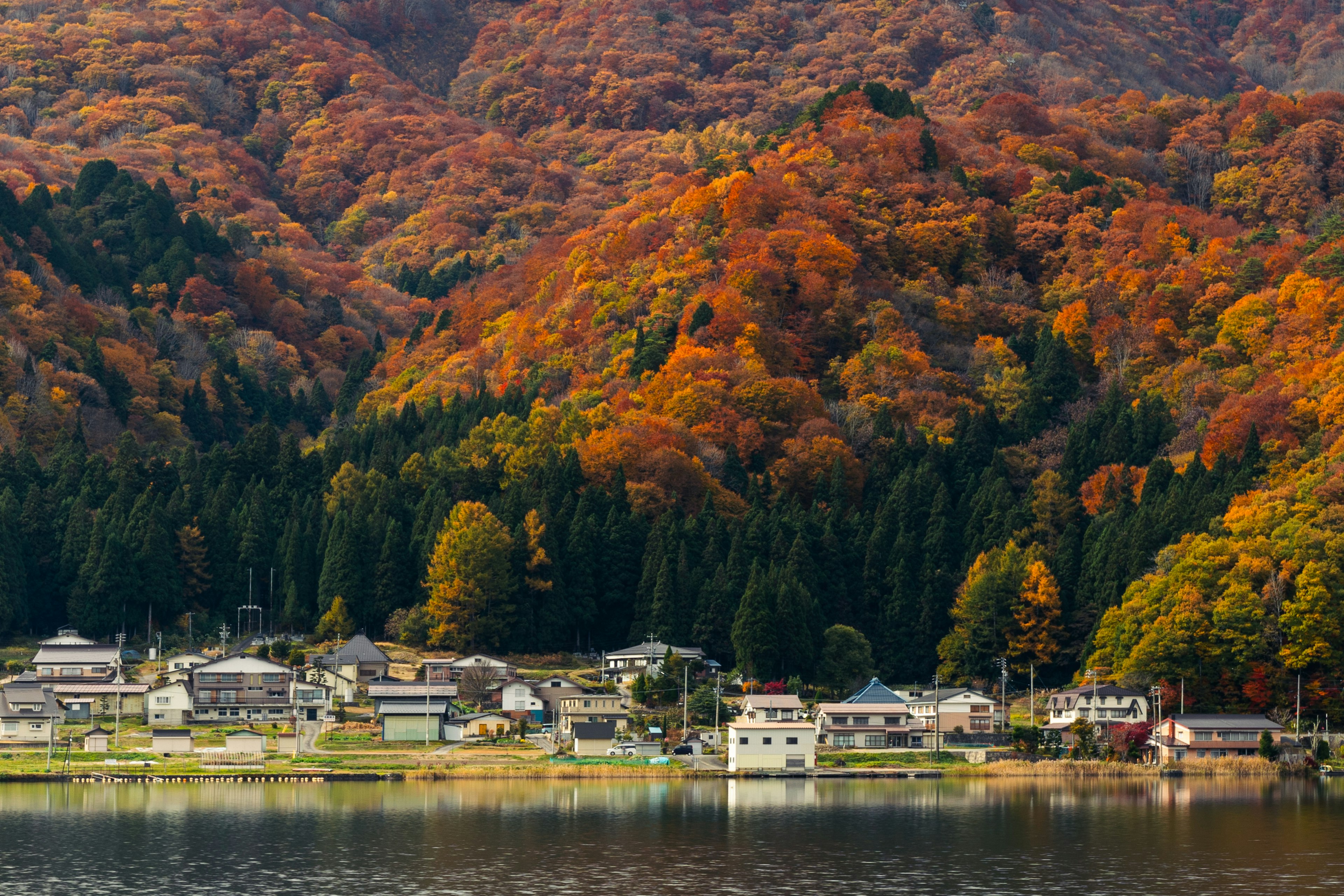 秋の色に染まった山々と静かな湖畔の集落