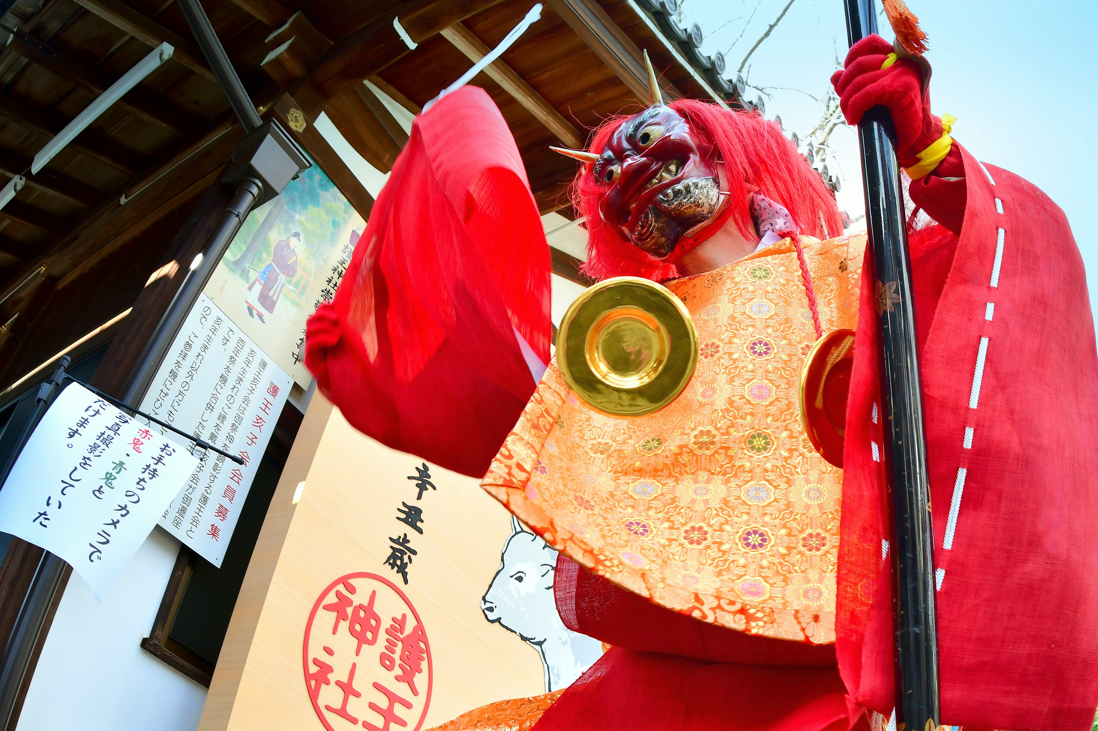 Personaje tradicional de festival con un atuendo rojo y una máscara de demonio