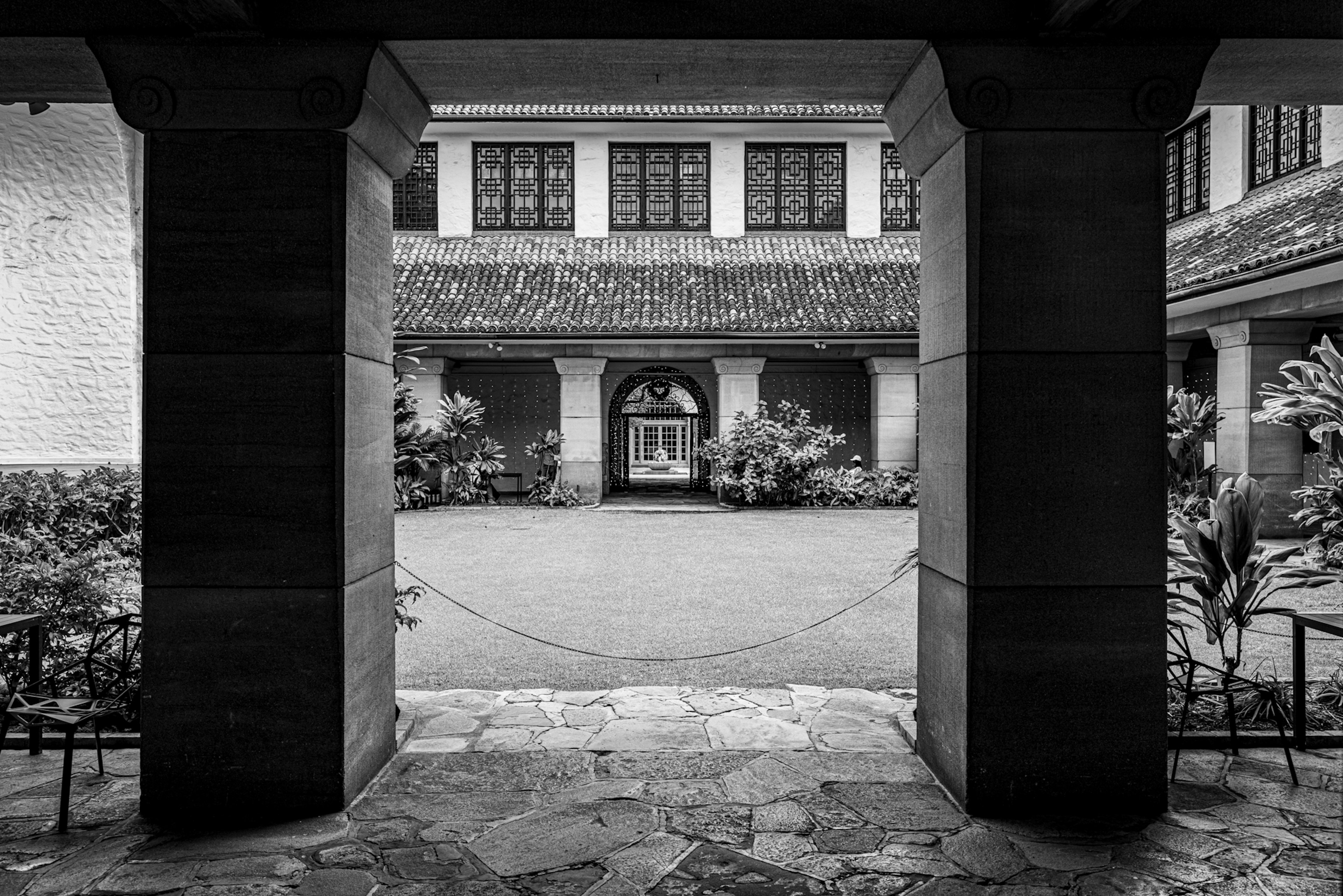 Vista de un arco hacia un patio sereno con vegetación