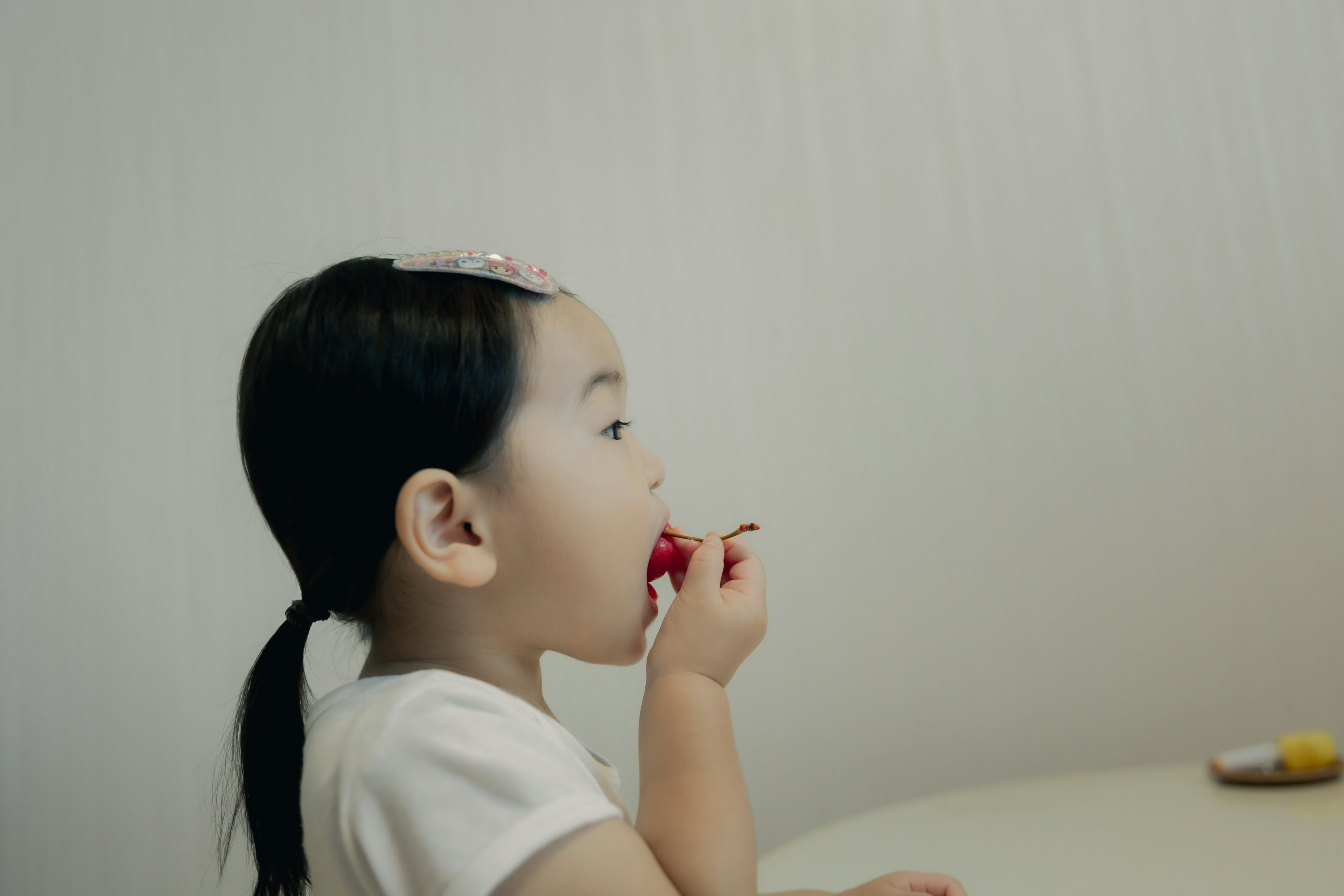 少女が赤いお菓子を食べている横顔