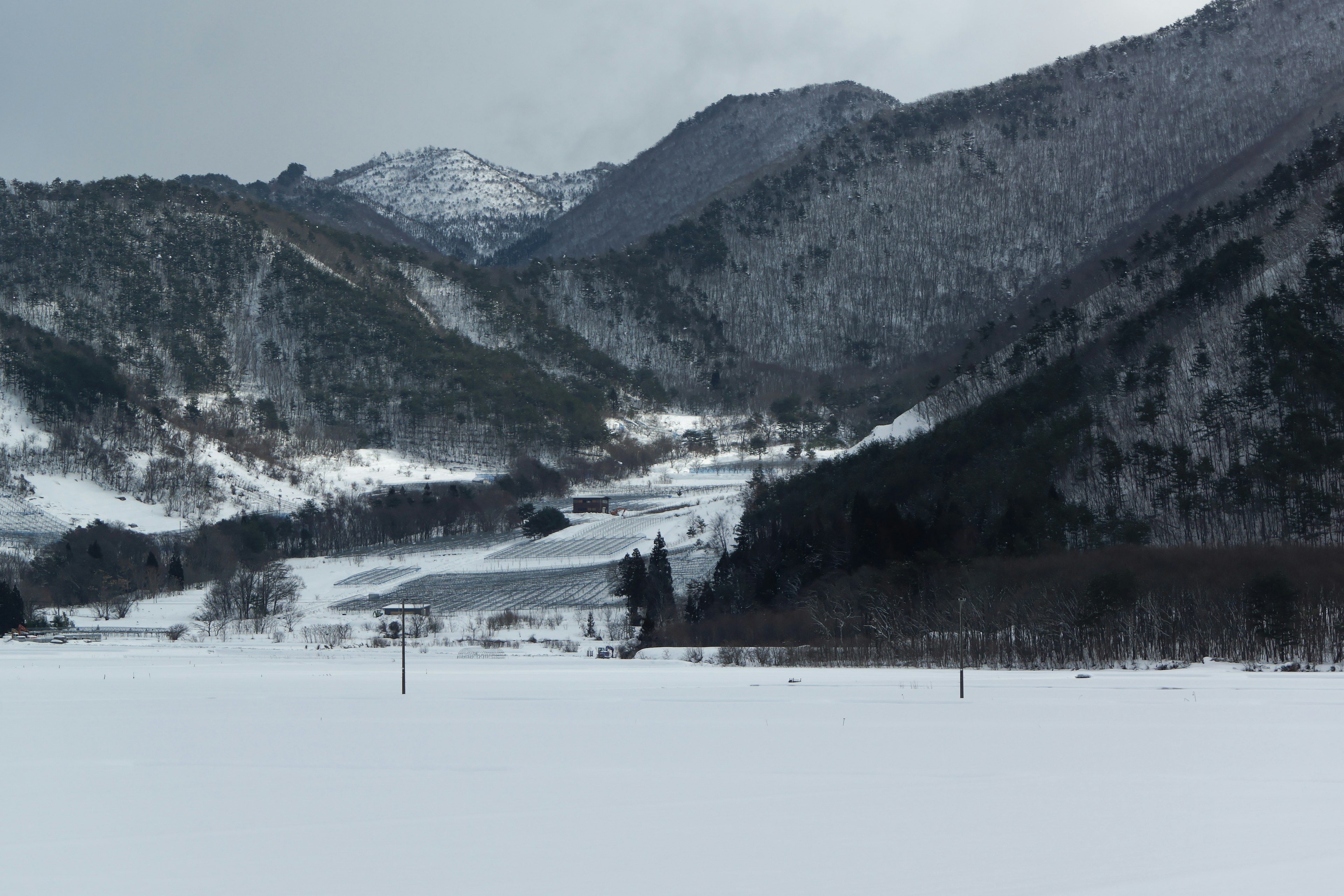 ทิวทัศน์ฤดูหนาวที่มีภูเขาและหุบเขาที่ปกคลุมไปด้วยหิมะ