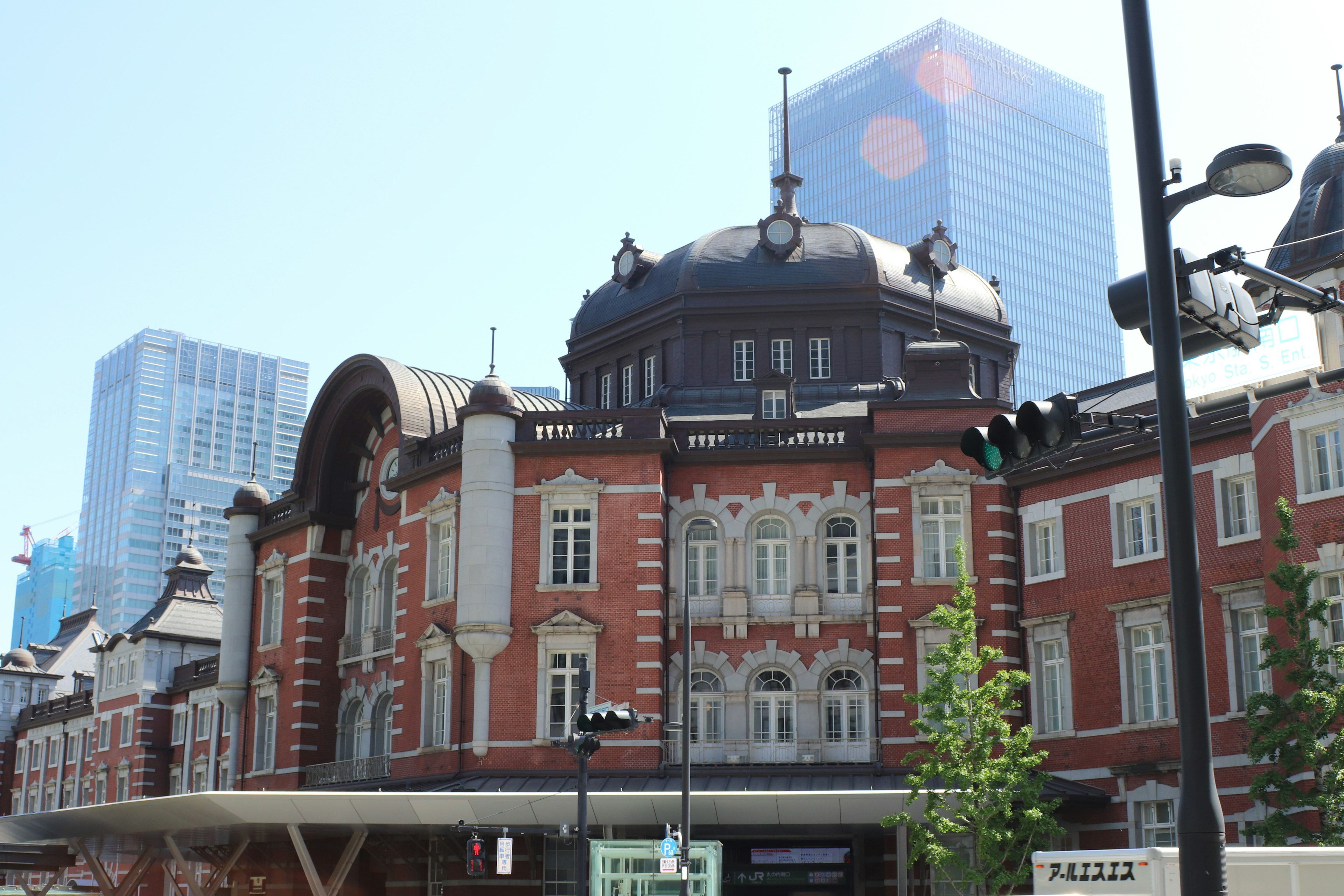 Tokyo Station's beautiful red brick building with modern skyscrapers in the background