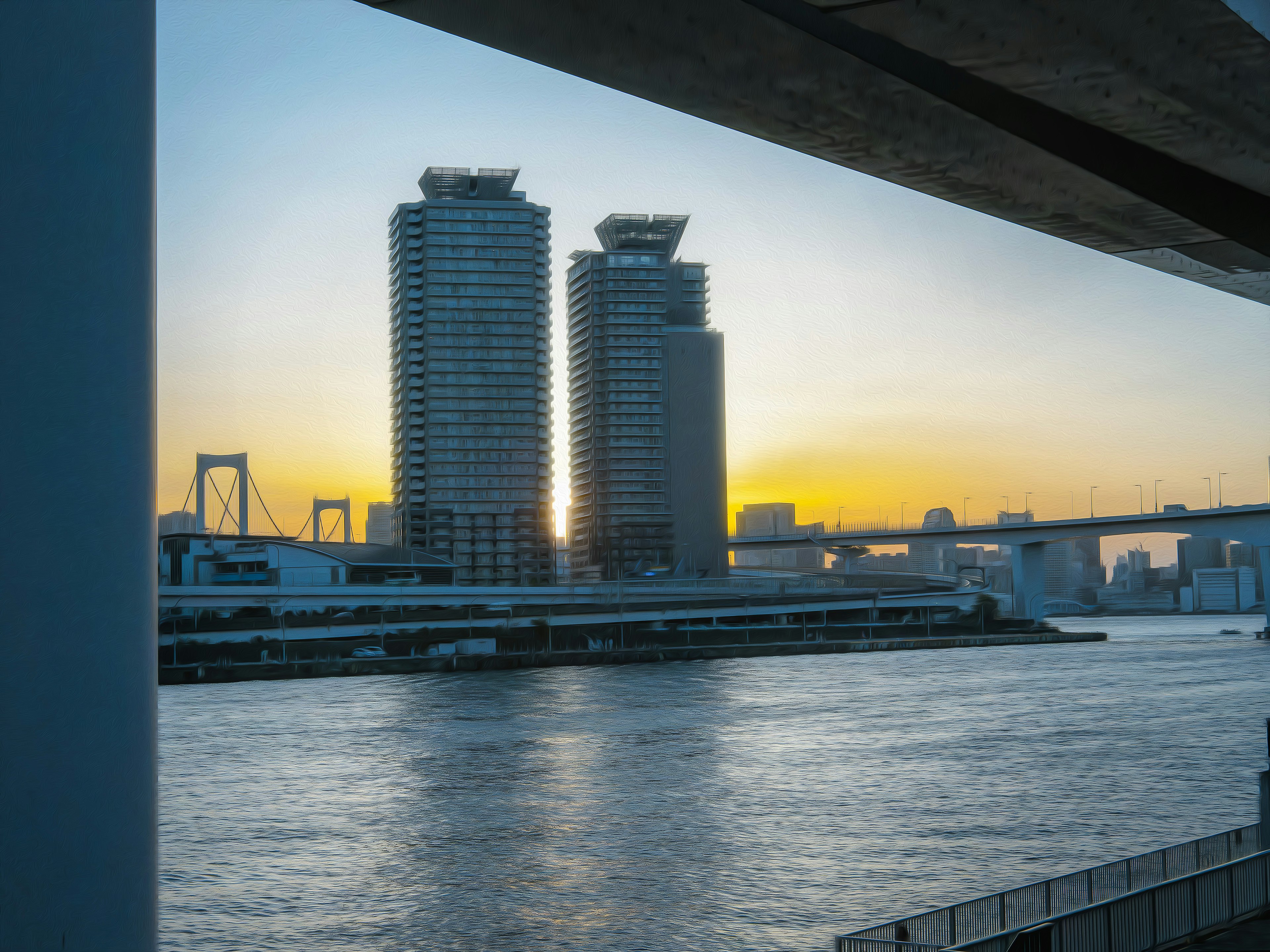 Twin skyscrapers glowing in sunset over the river