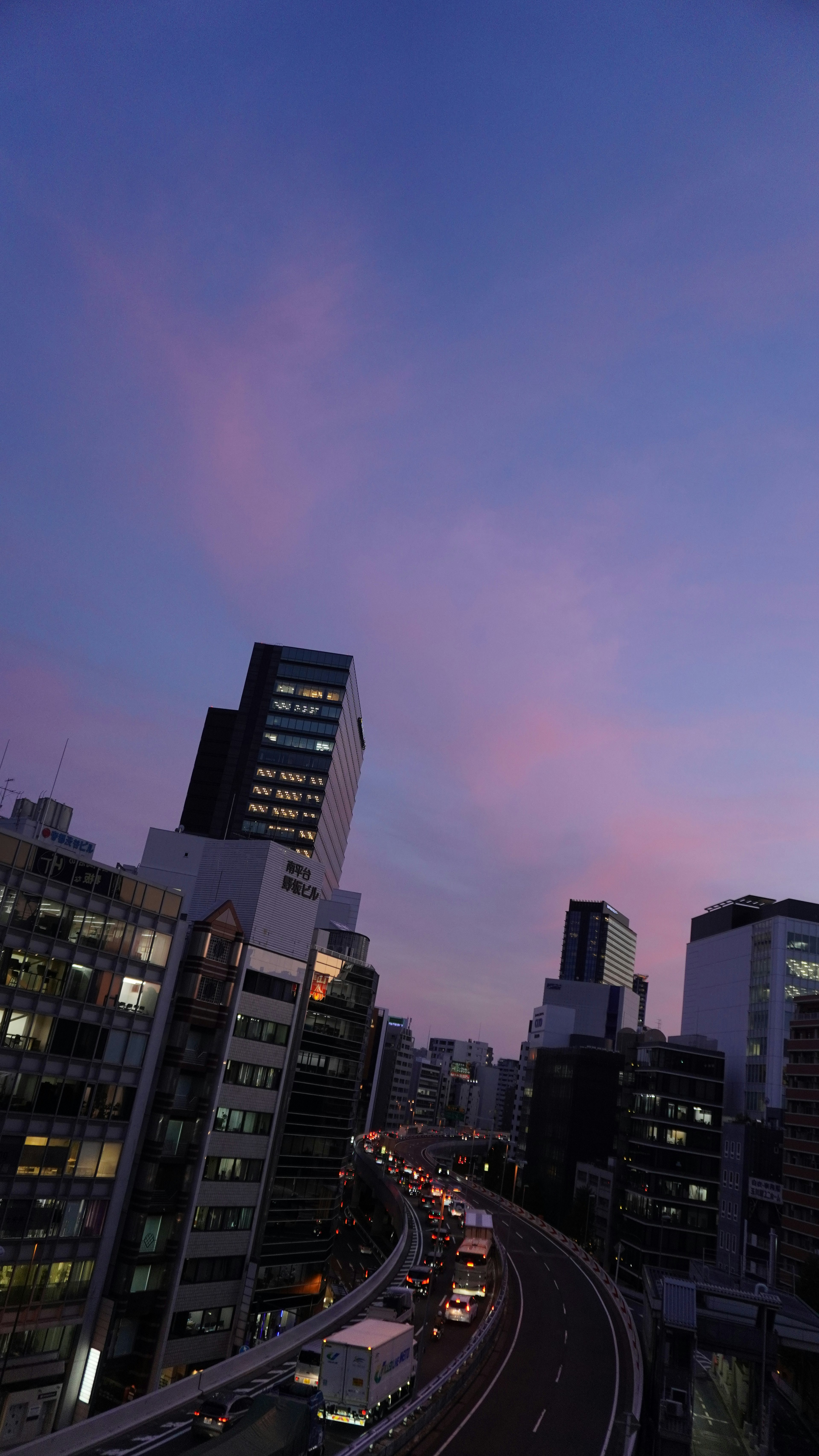 高層ビルと夕焼けの街並みを見下ろす風景