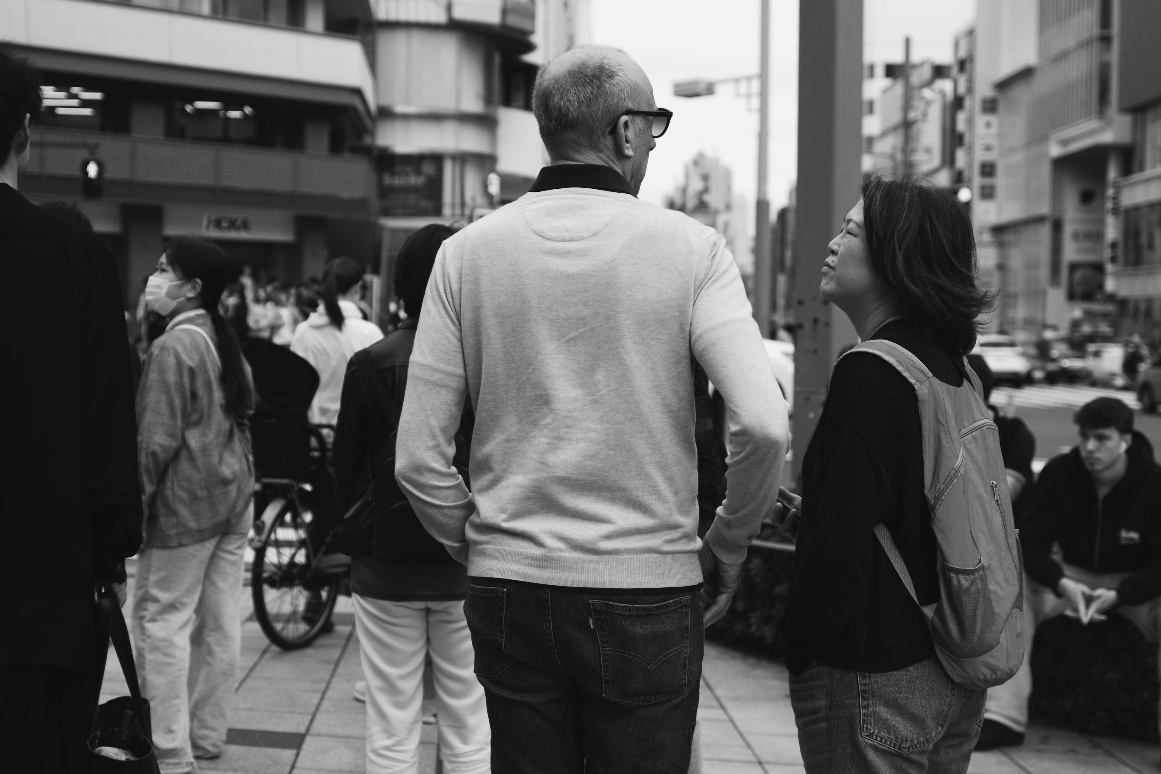 人々が集まる都市の通りで会話する二人の男女