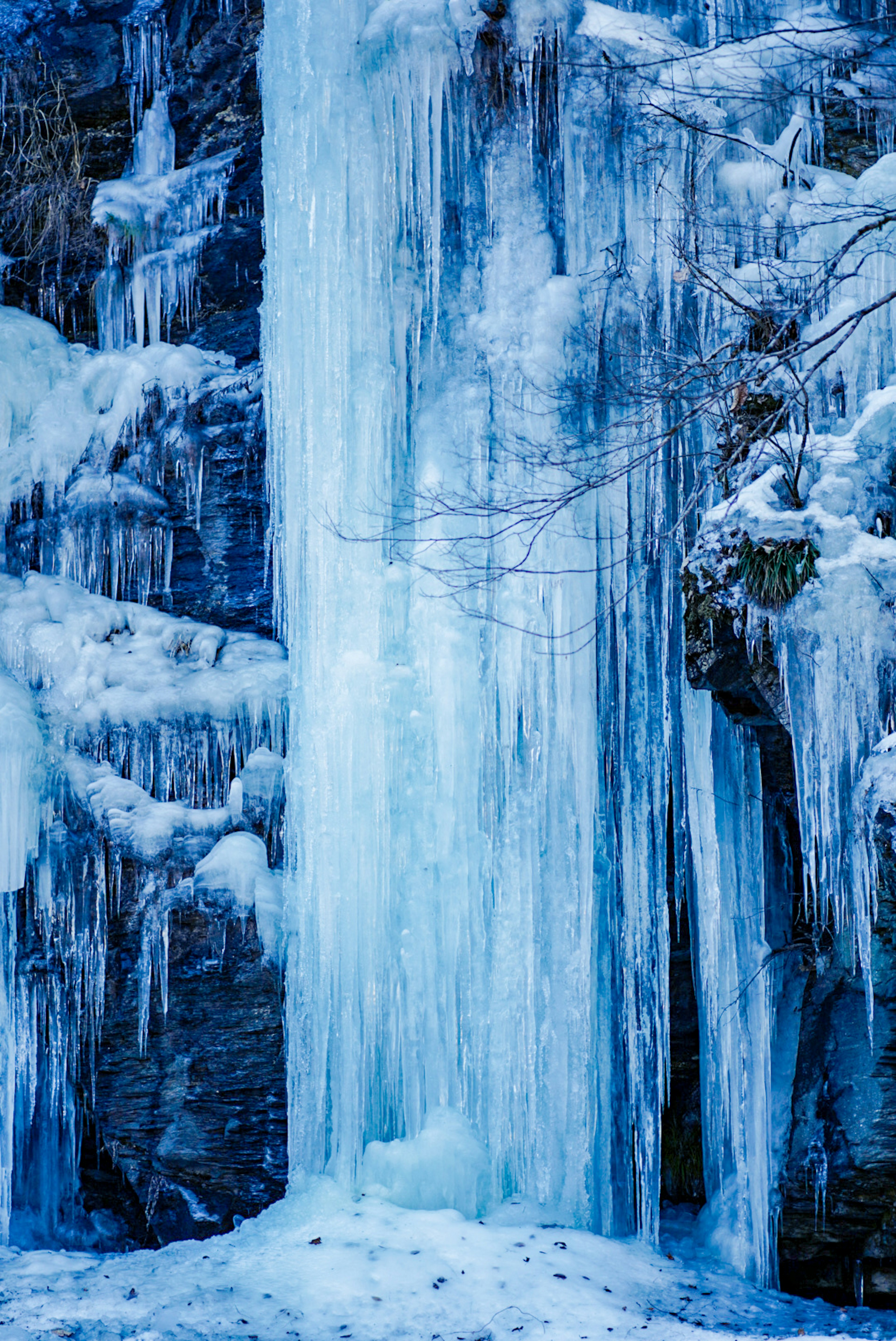 Una impresionante escena invernal con carámbanos que caen de una cascada congelada en tonos azules