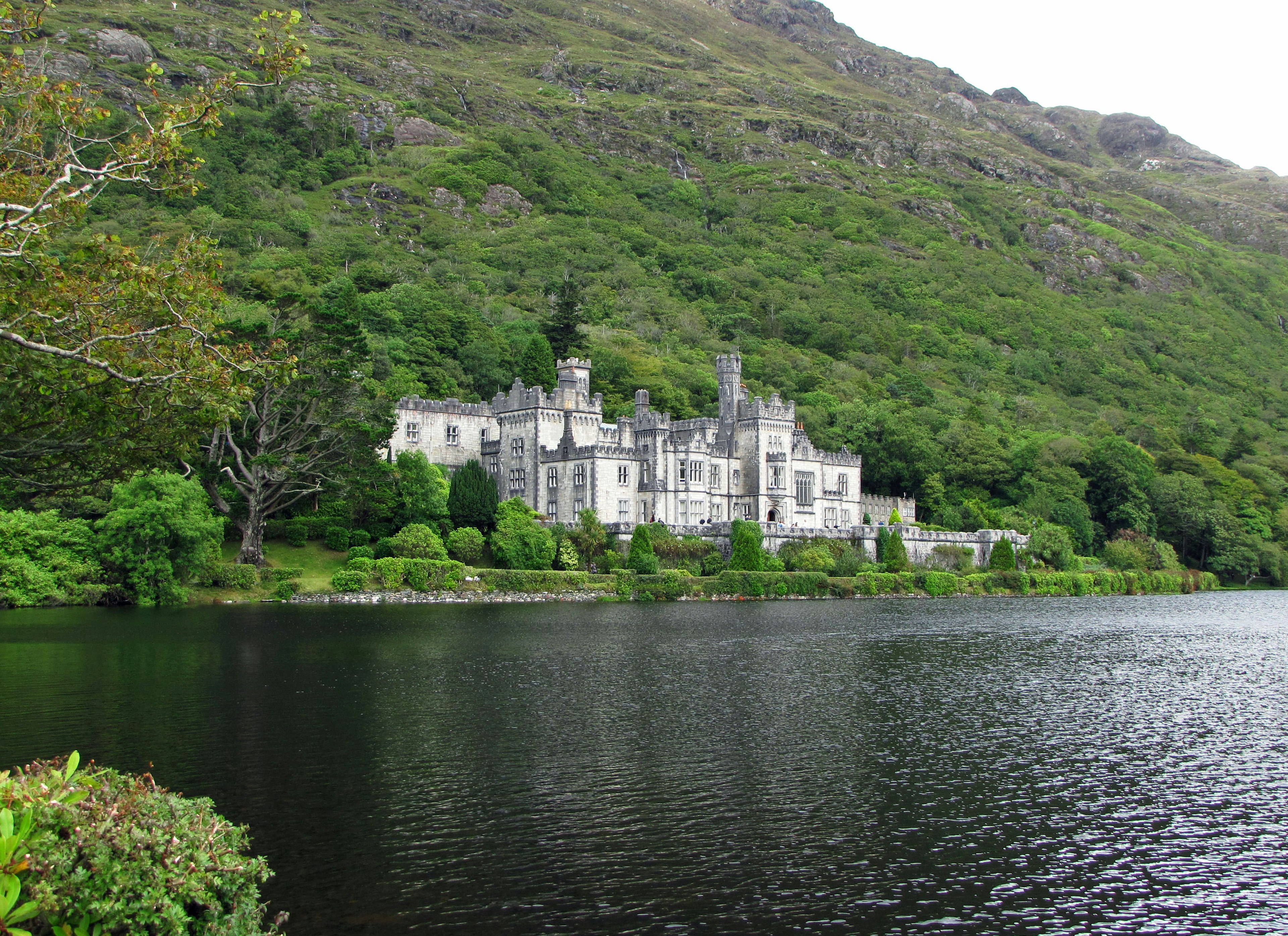 Un antico castello affacciato su un lago sereno circondato da vegetazione lussureggiante