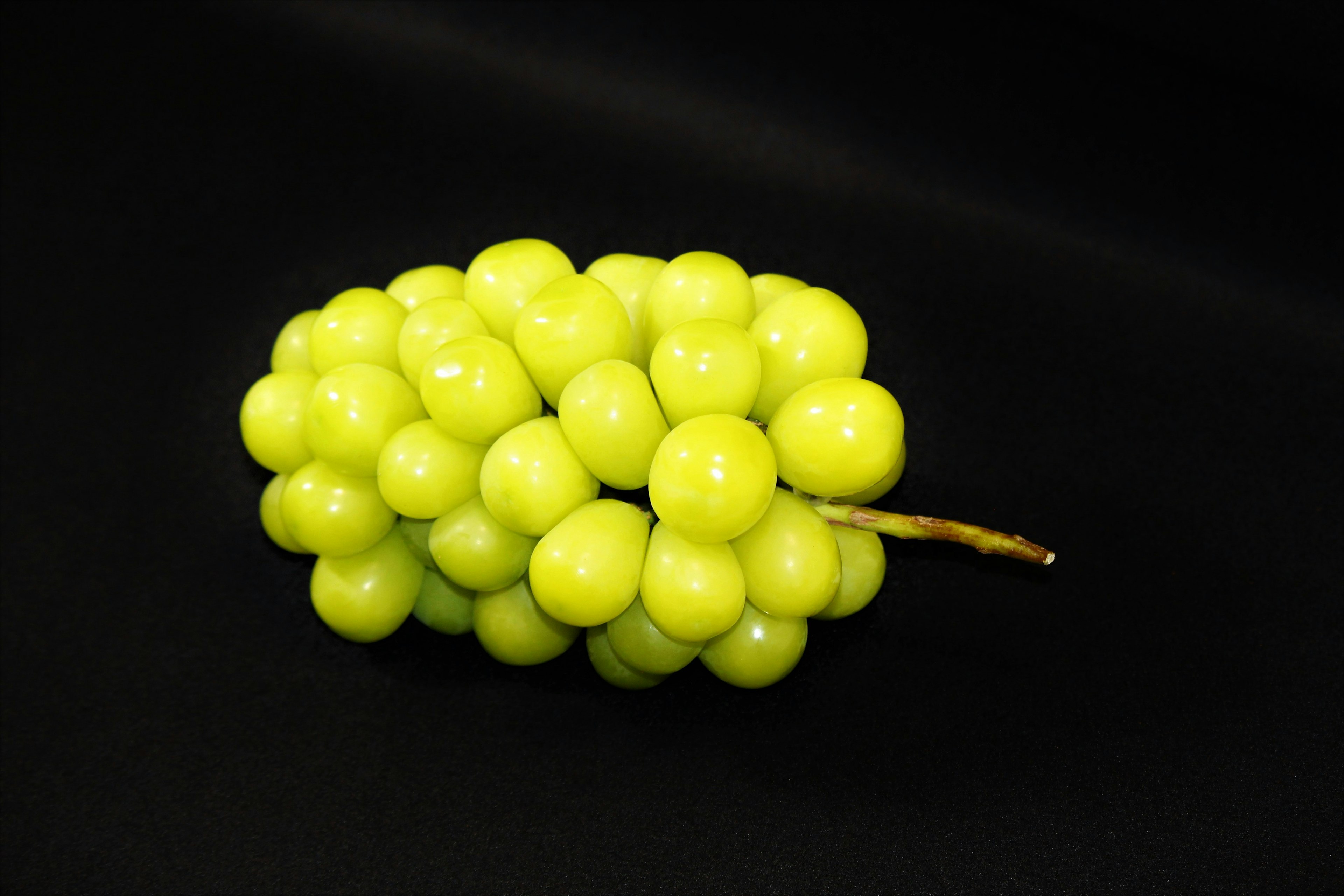 Racimo de uvas verdes sobre un fondo negro