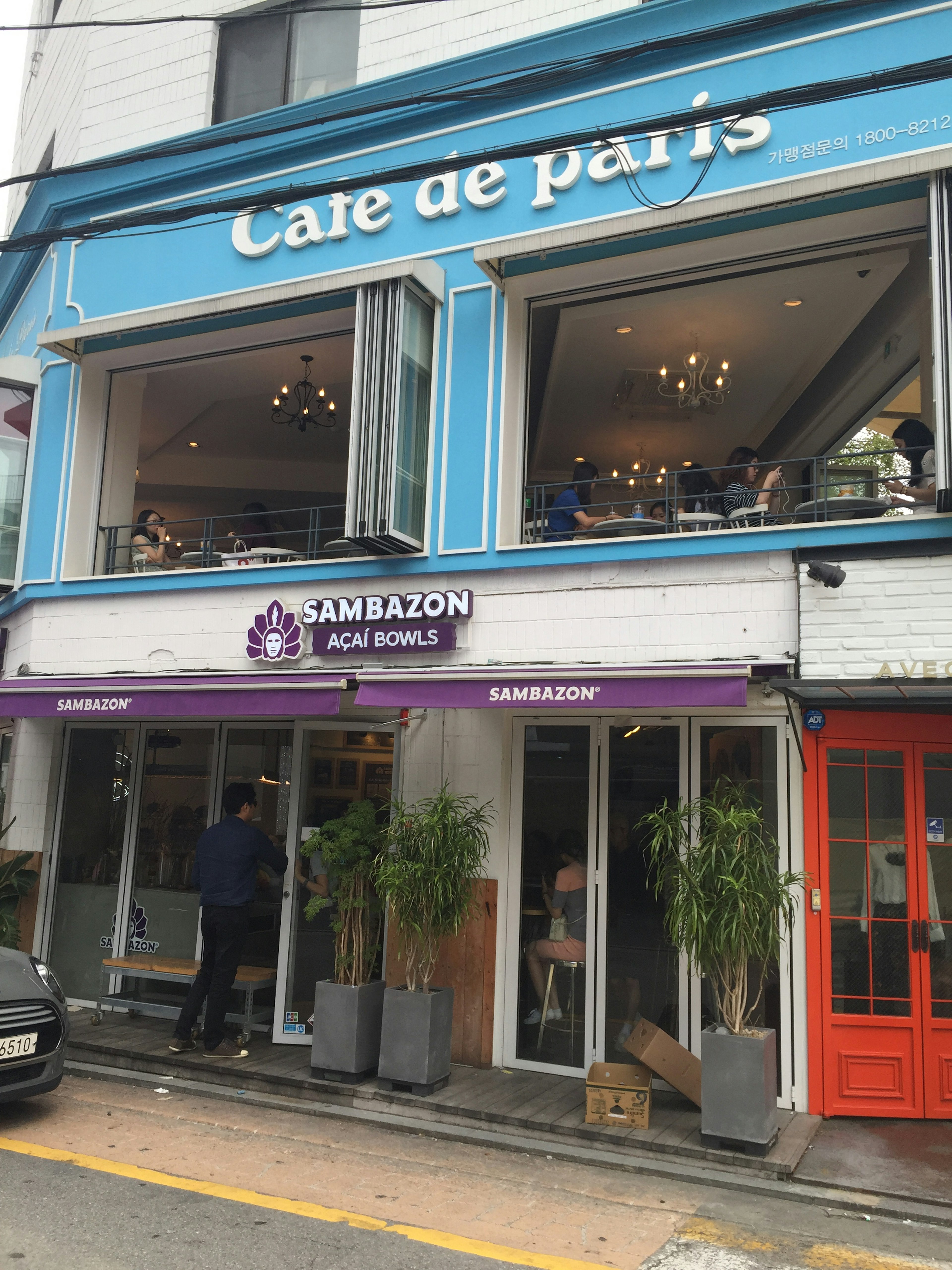 Cafe de Paris avec façade bleue et enseigne Sambazon Acai Bowls