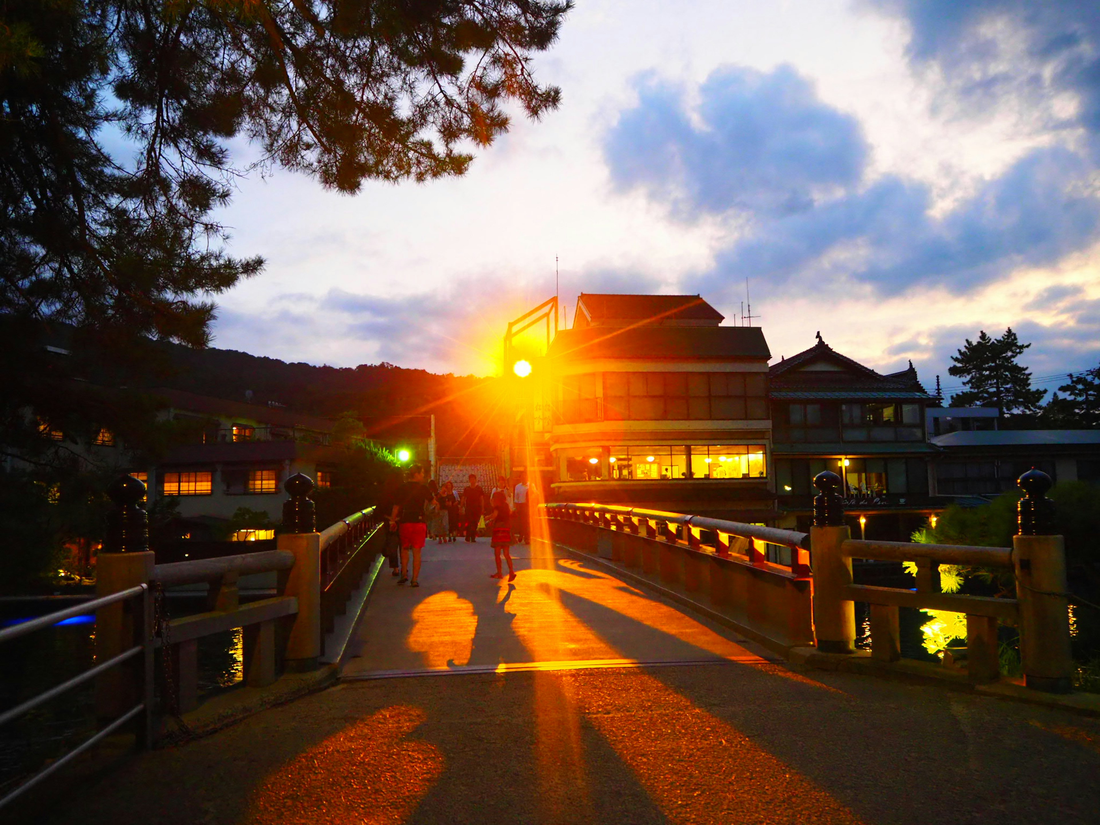 A sunset view of a bridge with an orange light illuminating a building