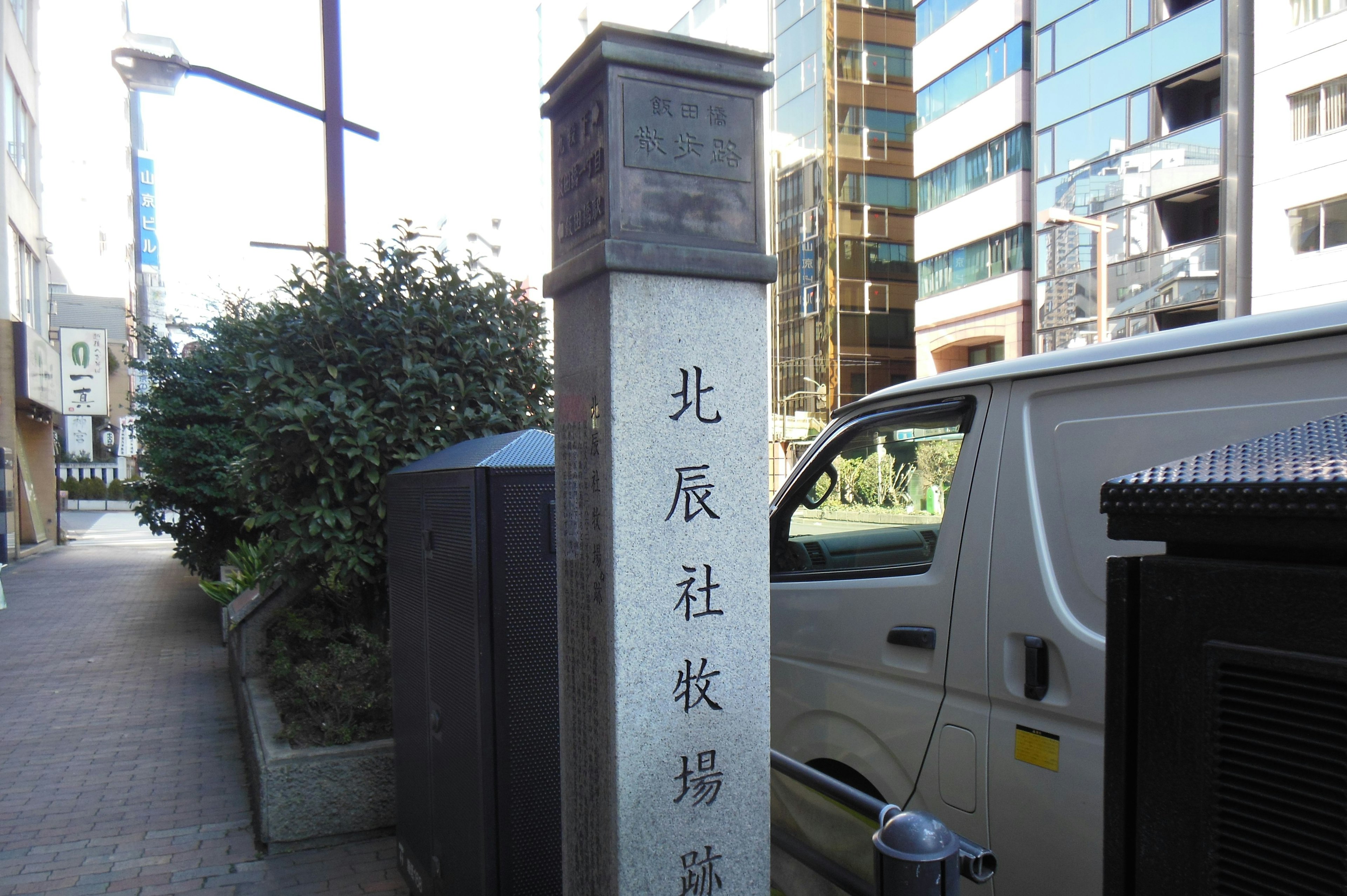 Vista de esquina de calle con un monumento de piedra de Hokushinsha