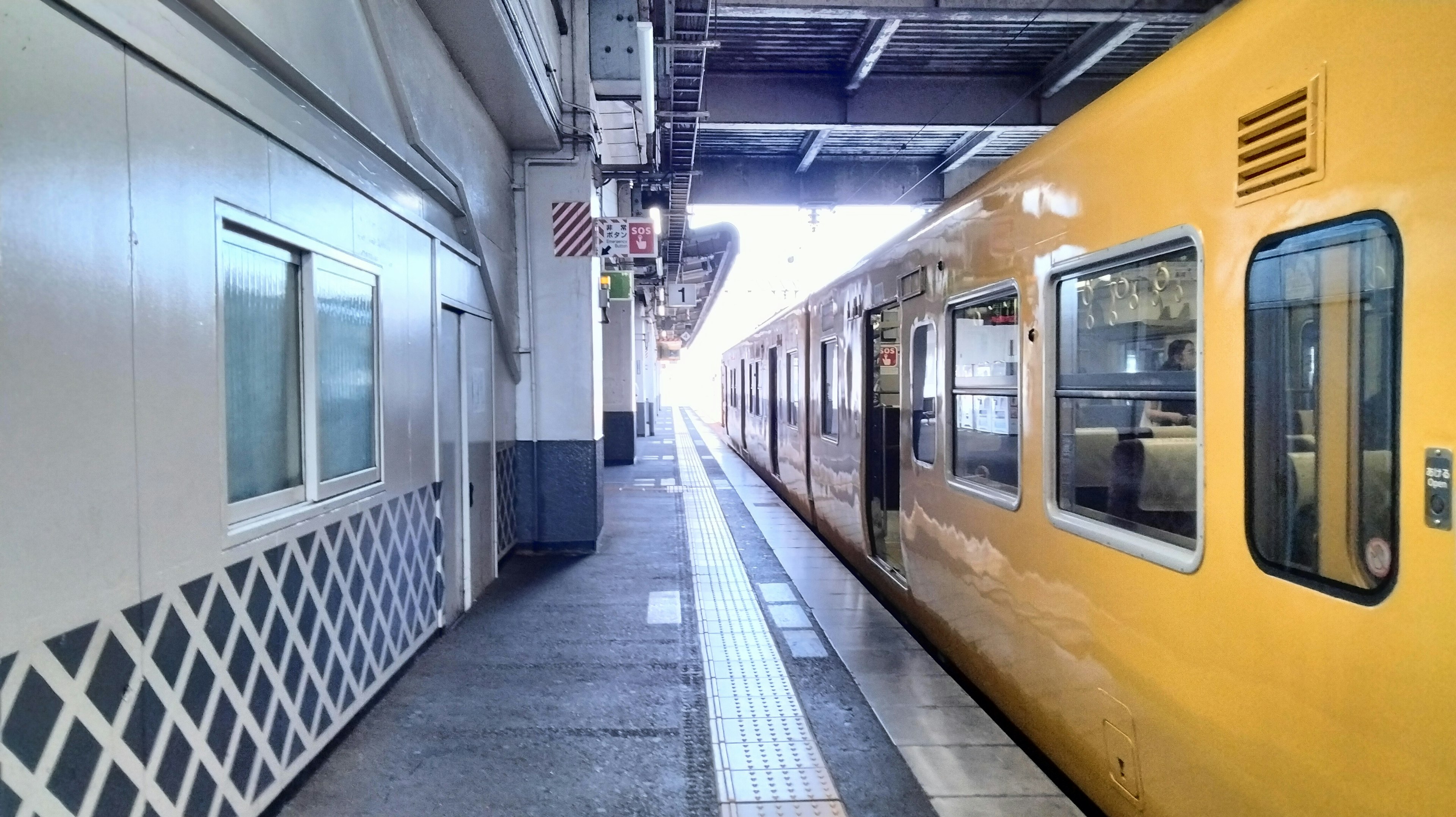 黄色い電車が停車している駅のプラットフォーム