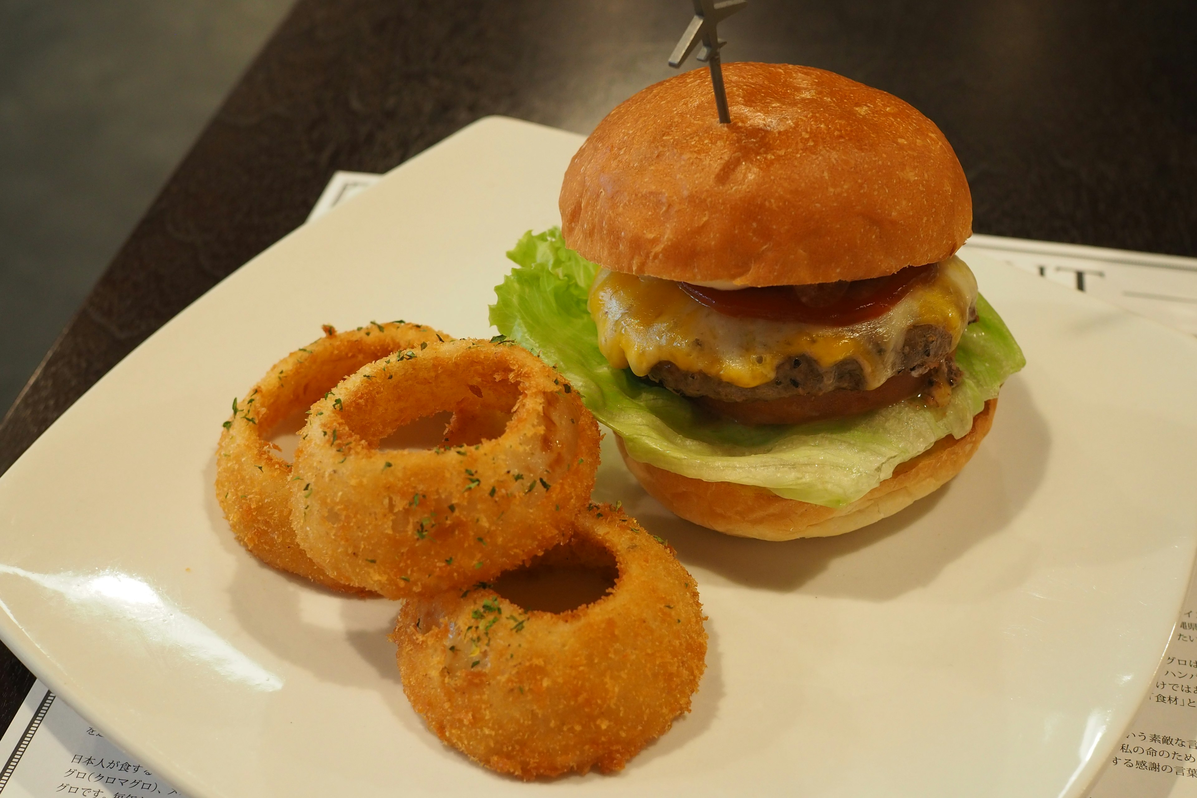 Hamburguesa deliciosa con lechuga y aros de cebolla en un plato