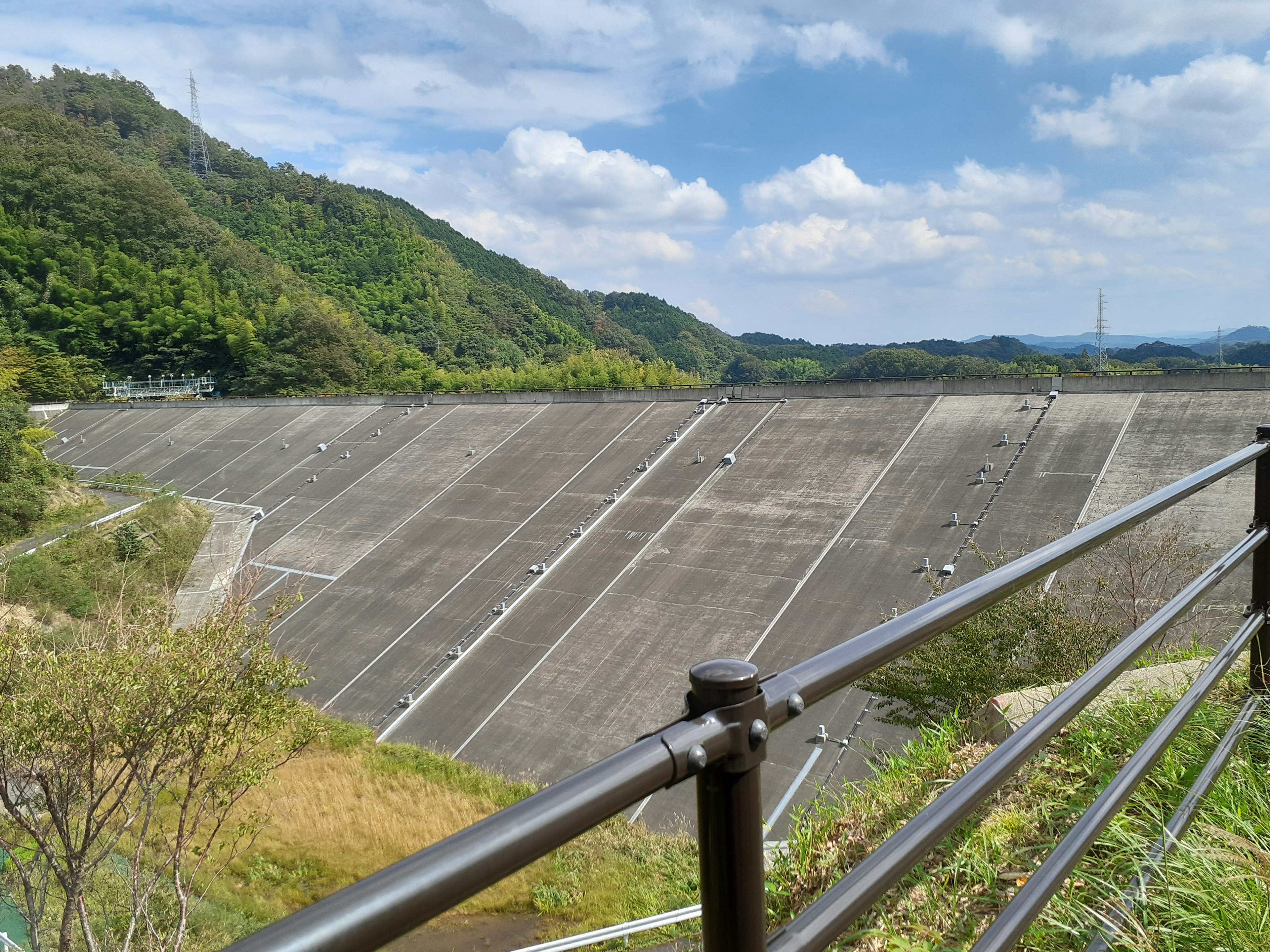 Represa de concreto rodeada de montañas y cielo azul