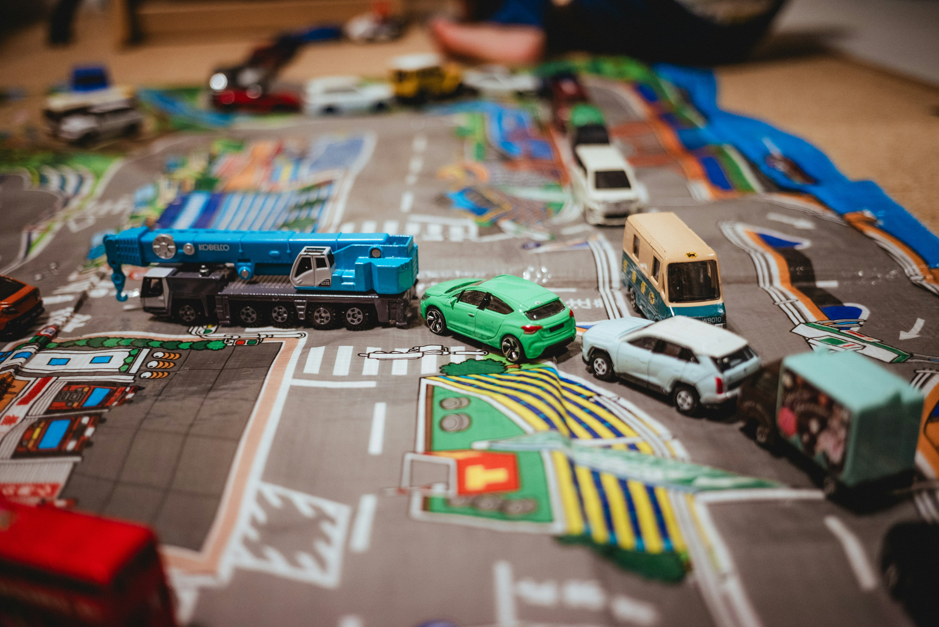 Coches de juguete dispuestos sobre una alfombra de carretera colorida