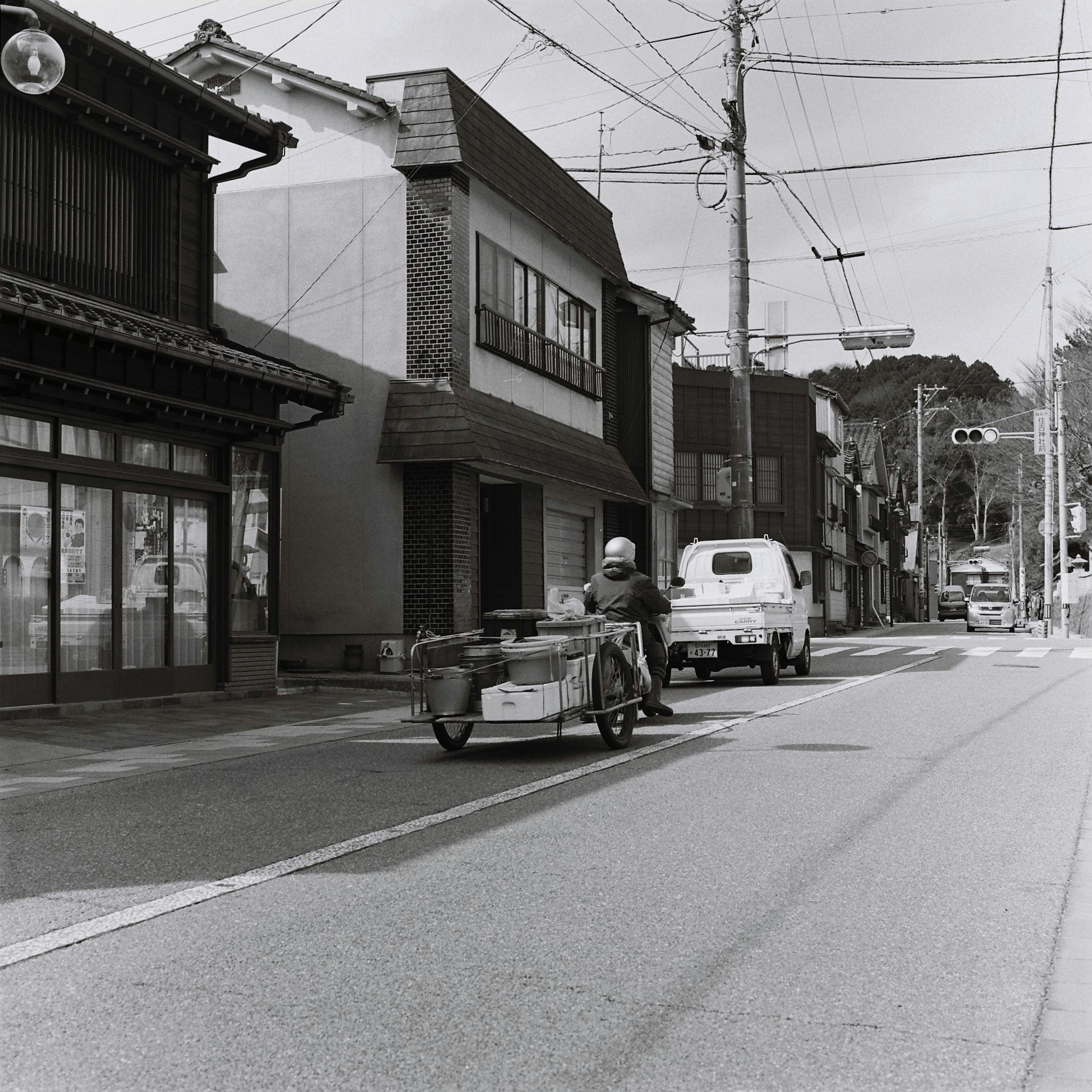 Schwarzweiß-Straßenszene mit Motorrad und Beiwagen