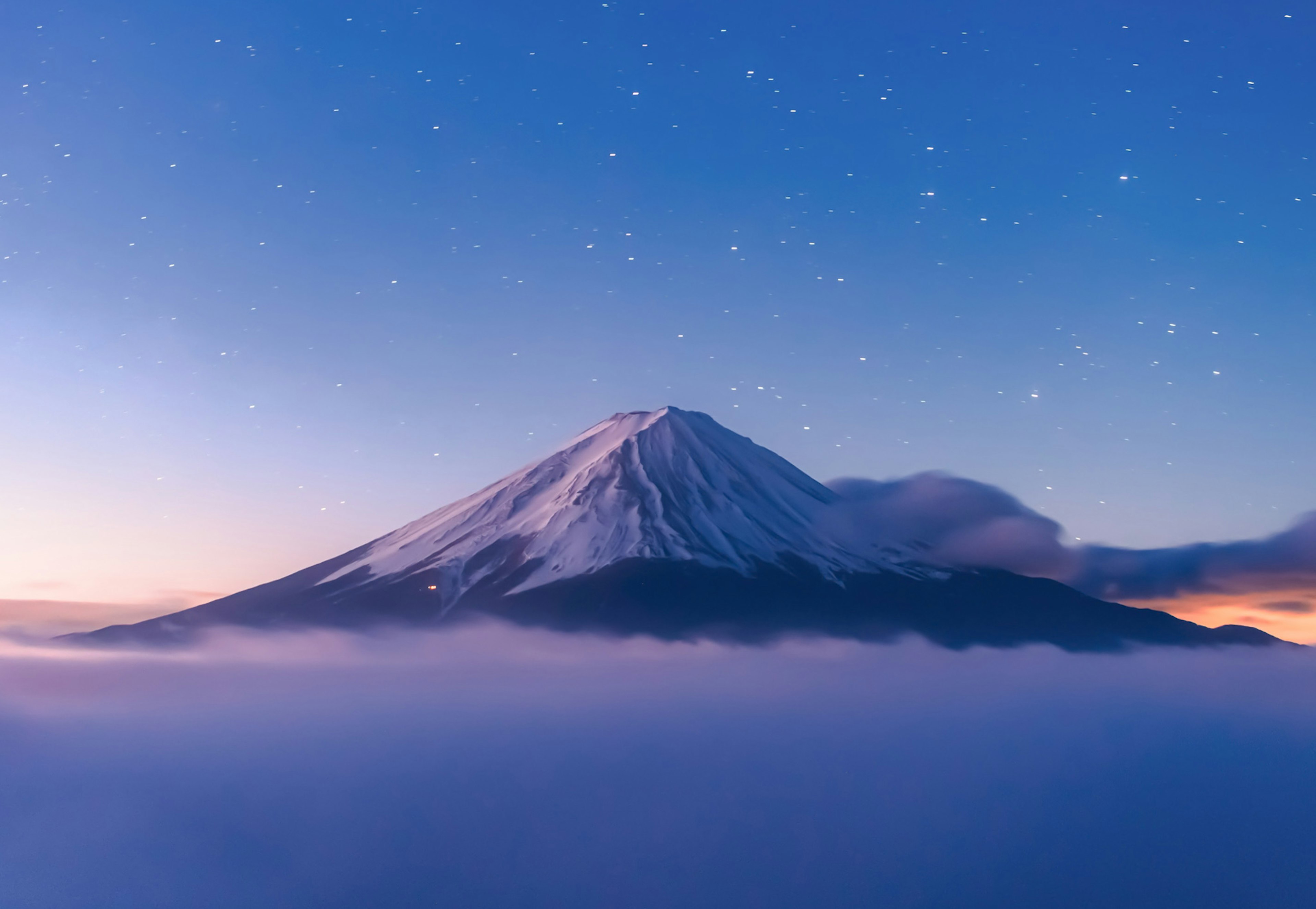 雪をかぶった富士山が青い空と雲に囲まれている美しい風景