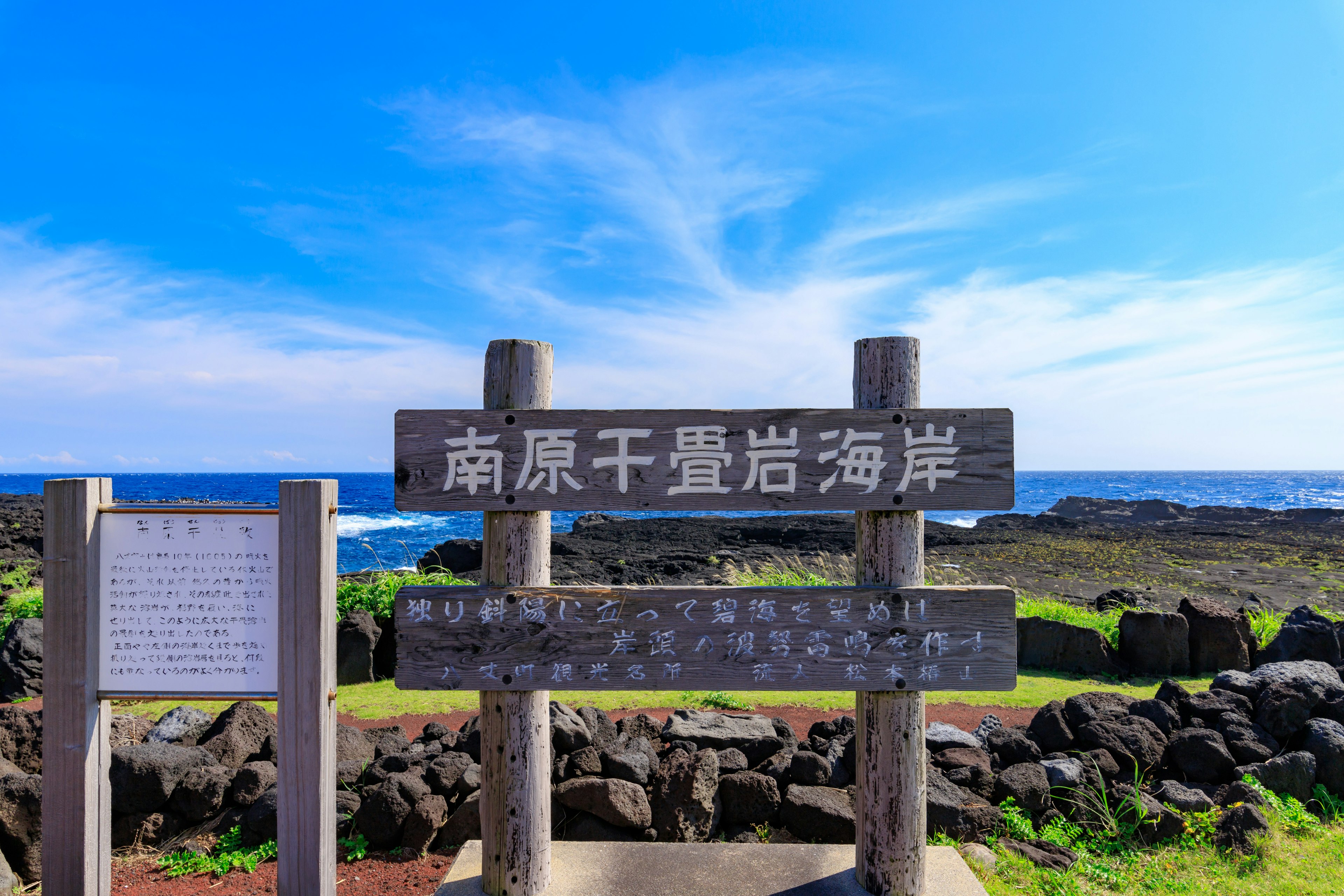 南原干磊岩海岸の看板と青い空