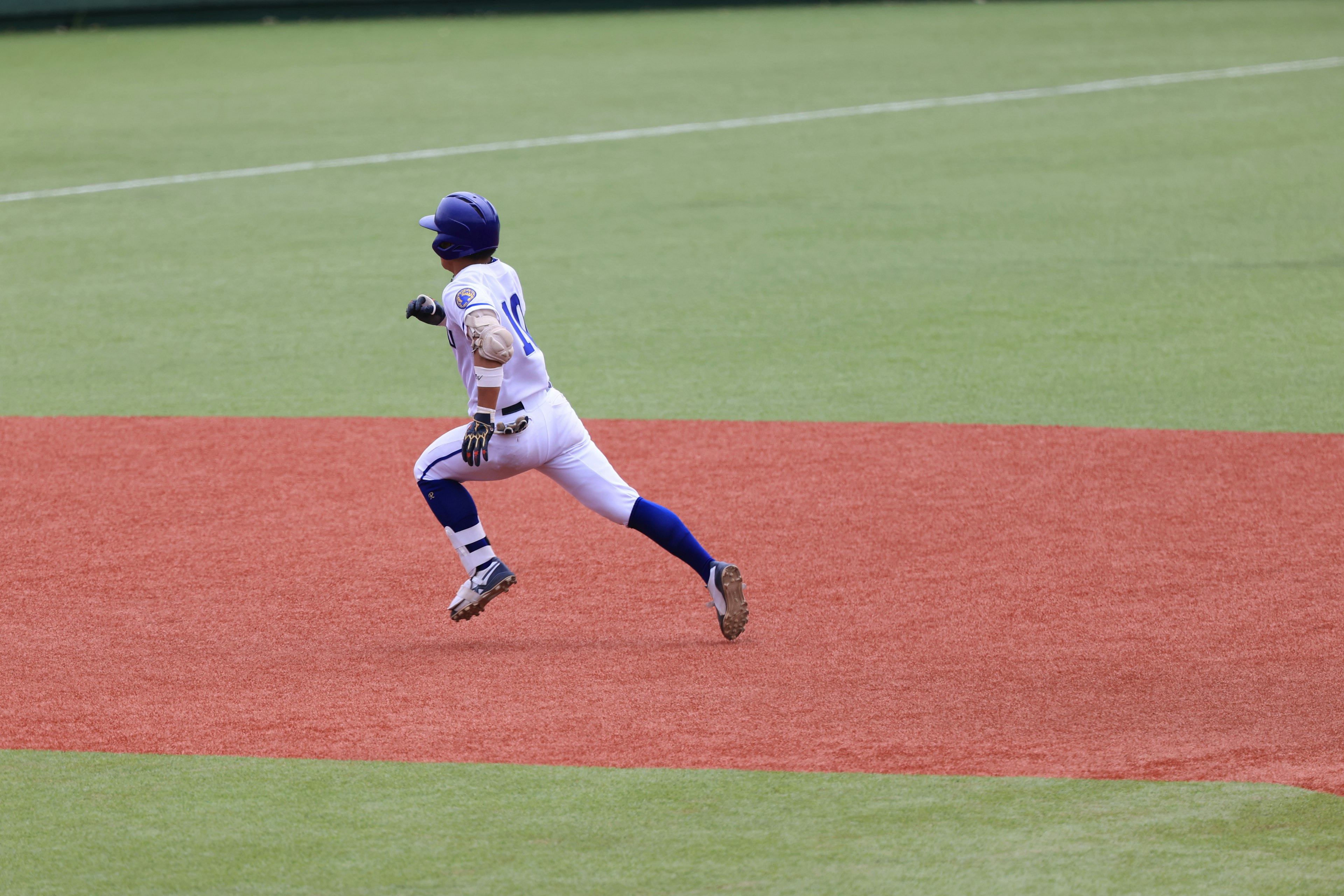 Baseball player running across the field during a game