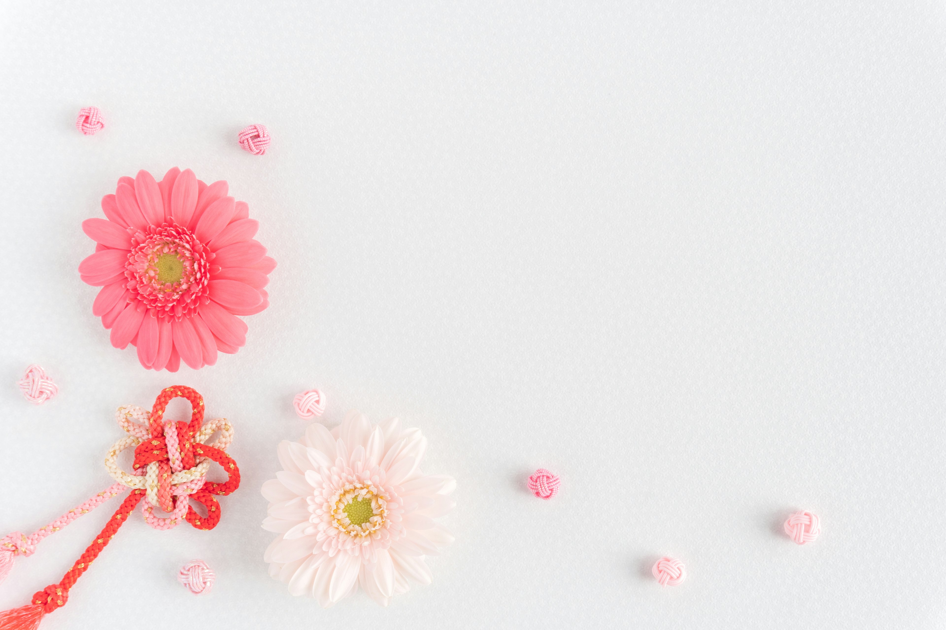 Flores rosas y blancas dispuestas sobre un fondo blanco con pequeños elementos decorativos