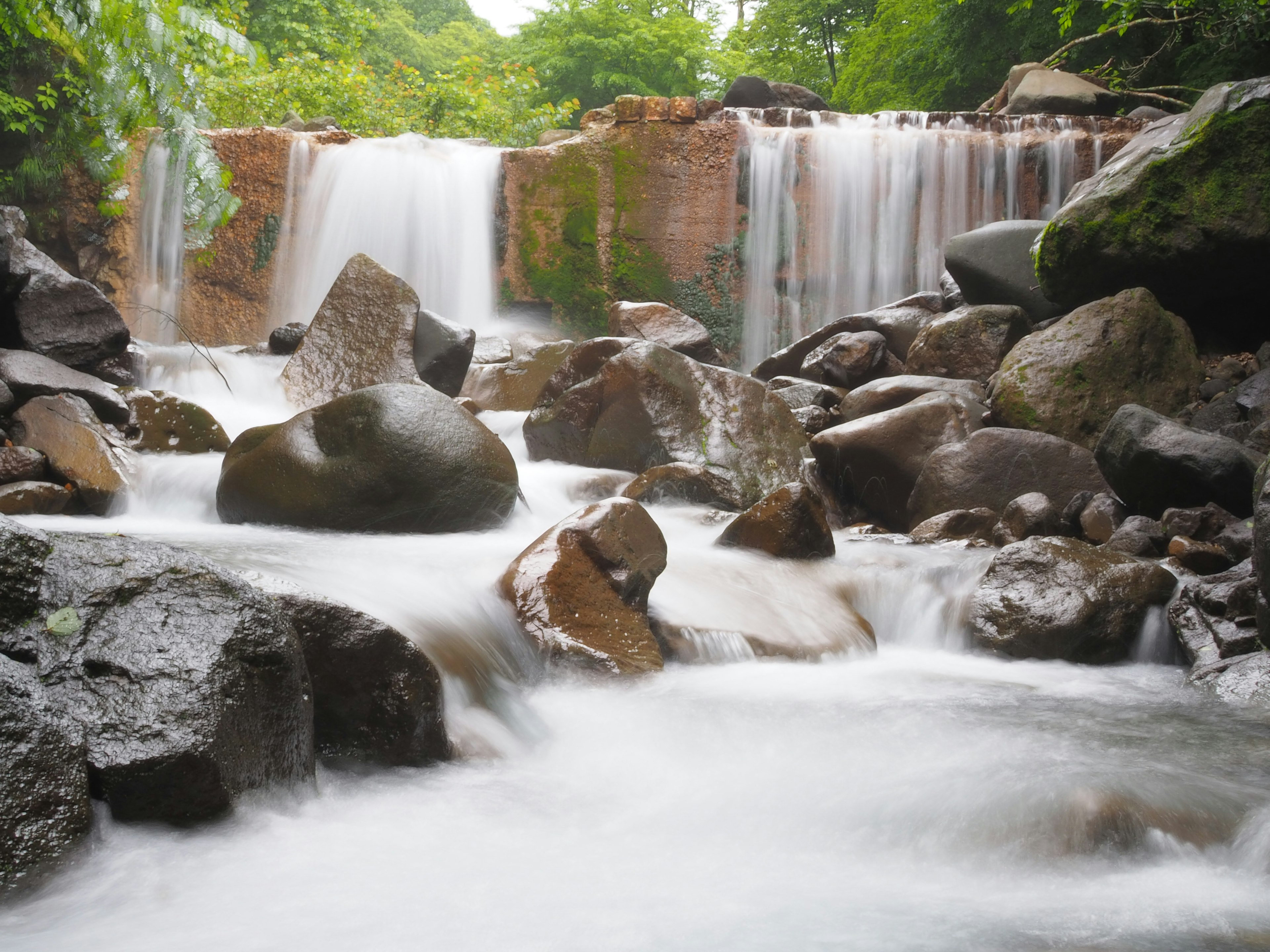 Pemandangan indah air mengalir dan batu di air terjun