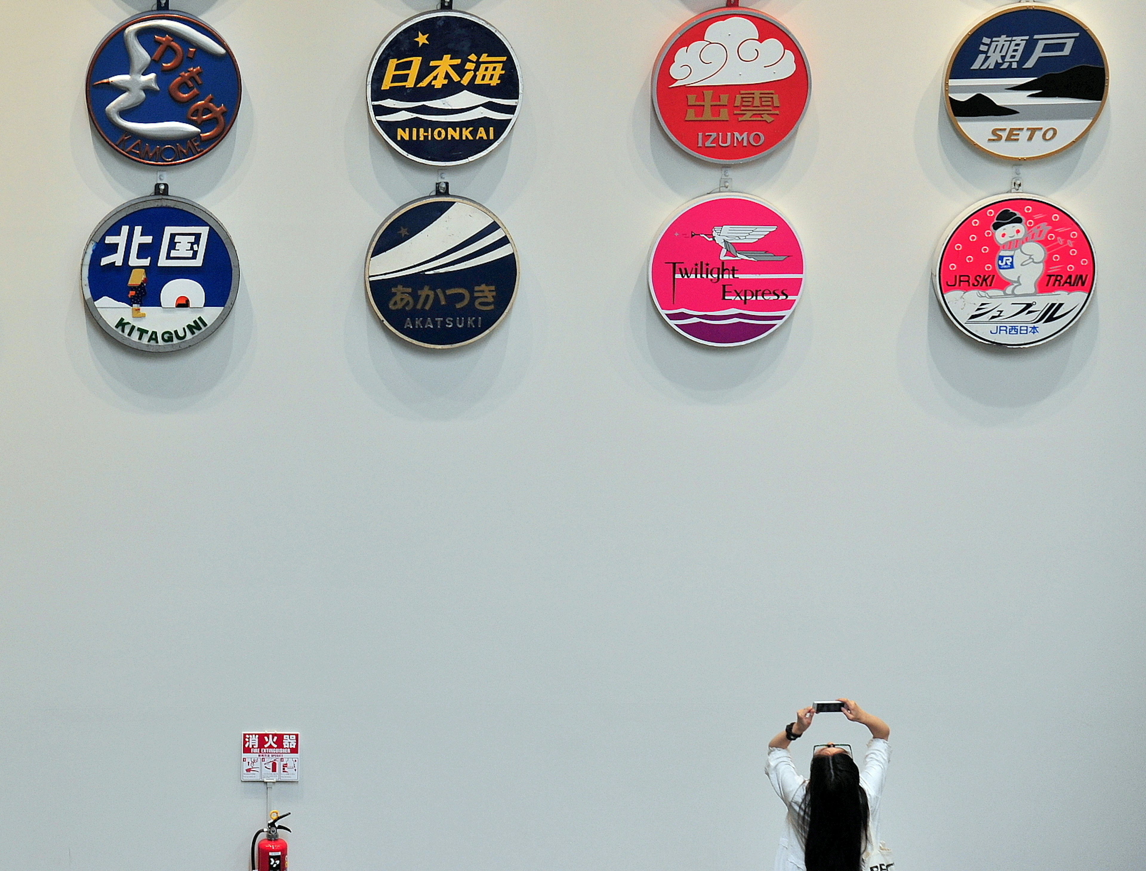 Una mujer mirando hacia arriba a logos y símbolos coloridos en una pared