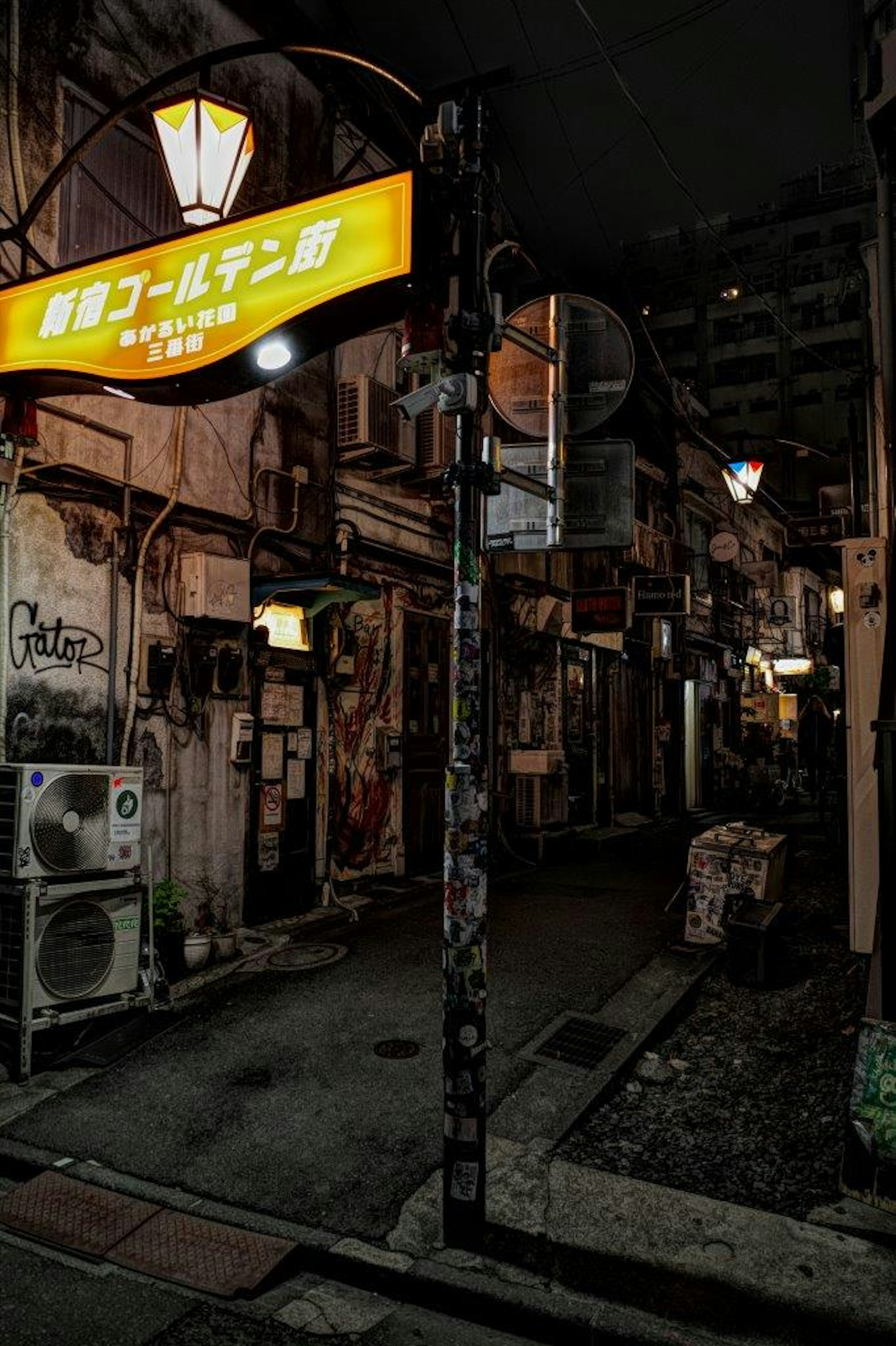 Exterior of a restaurant with a yellow sign in a dark alley