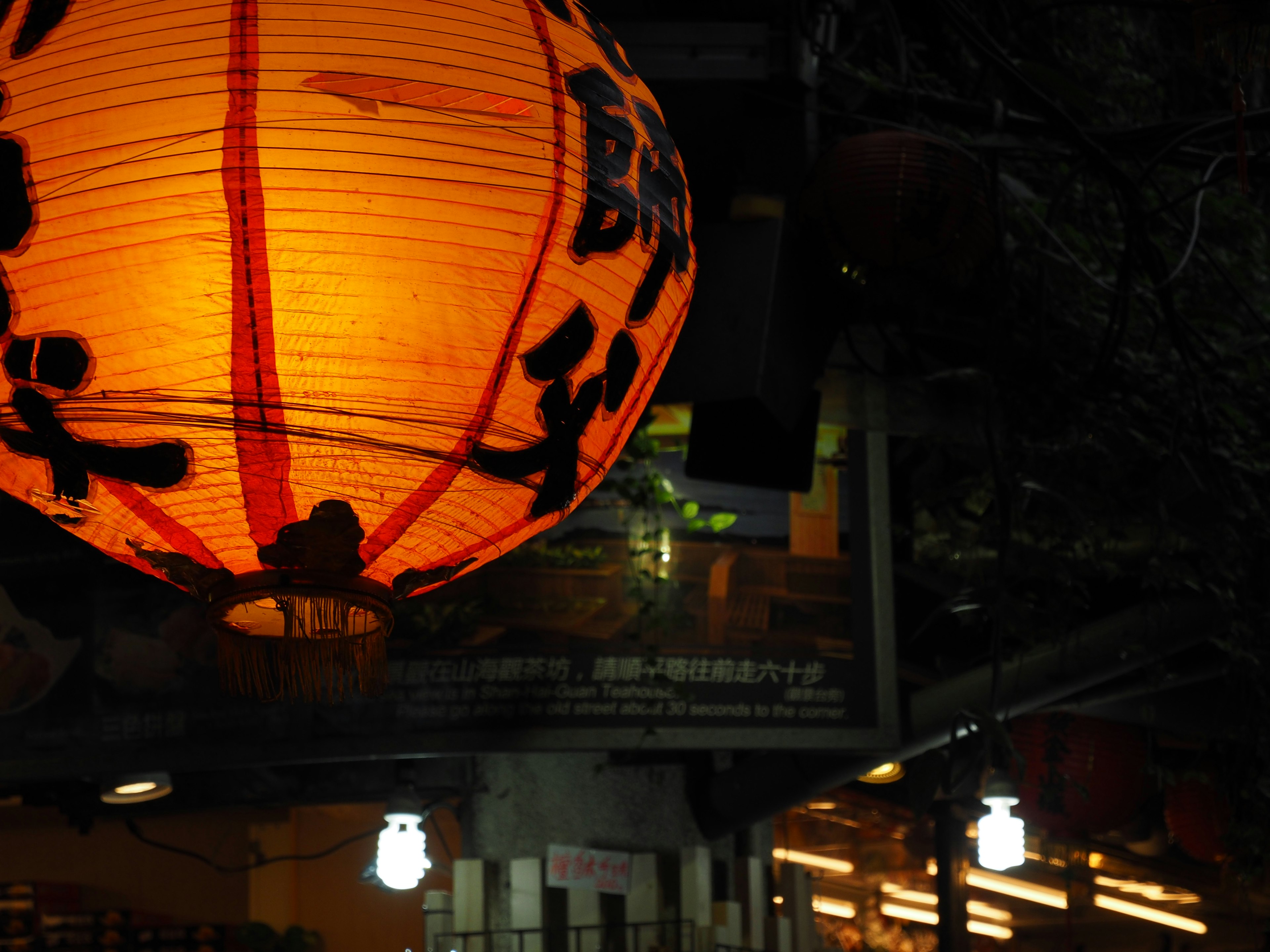 Lanternes orange illuminant la nuit avec des caractères japonais