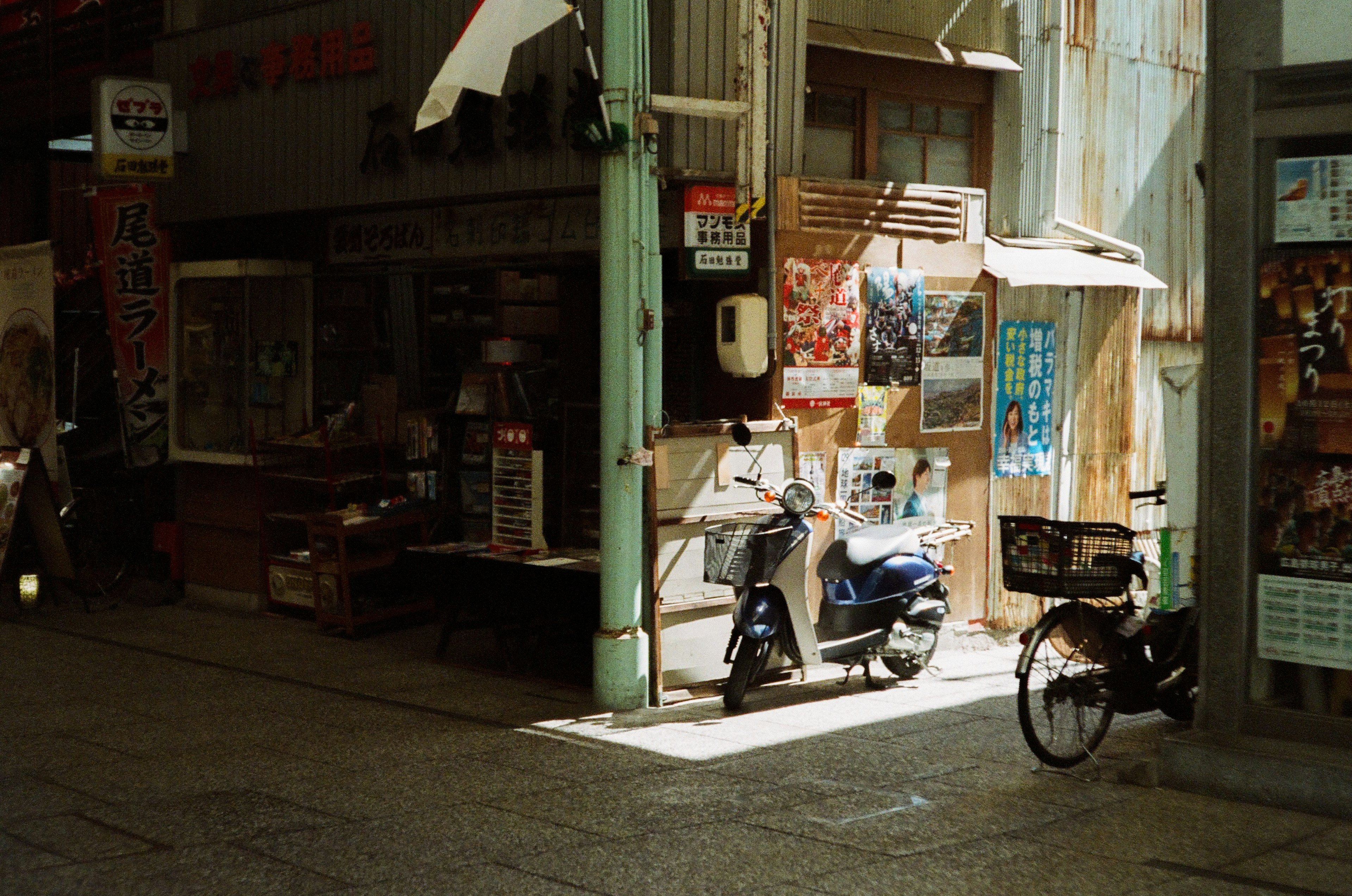 街角にある小さな店とバイクが並ぶ静かな通りの風景