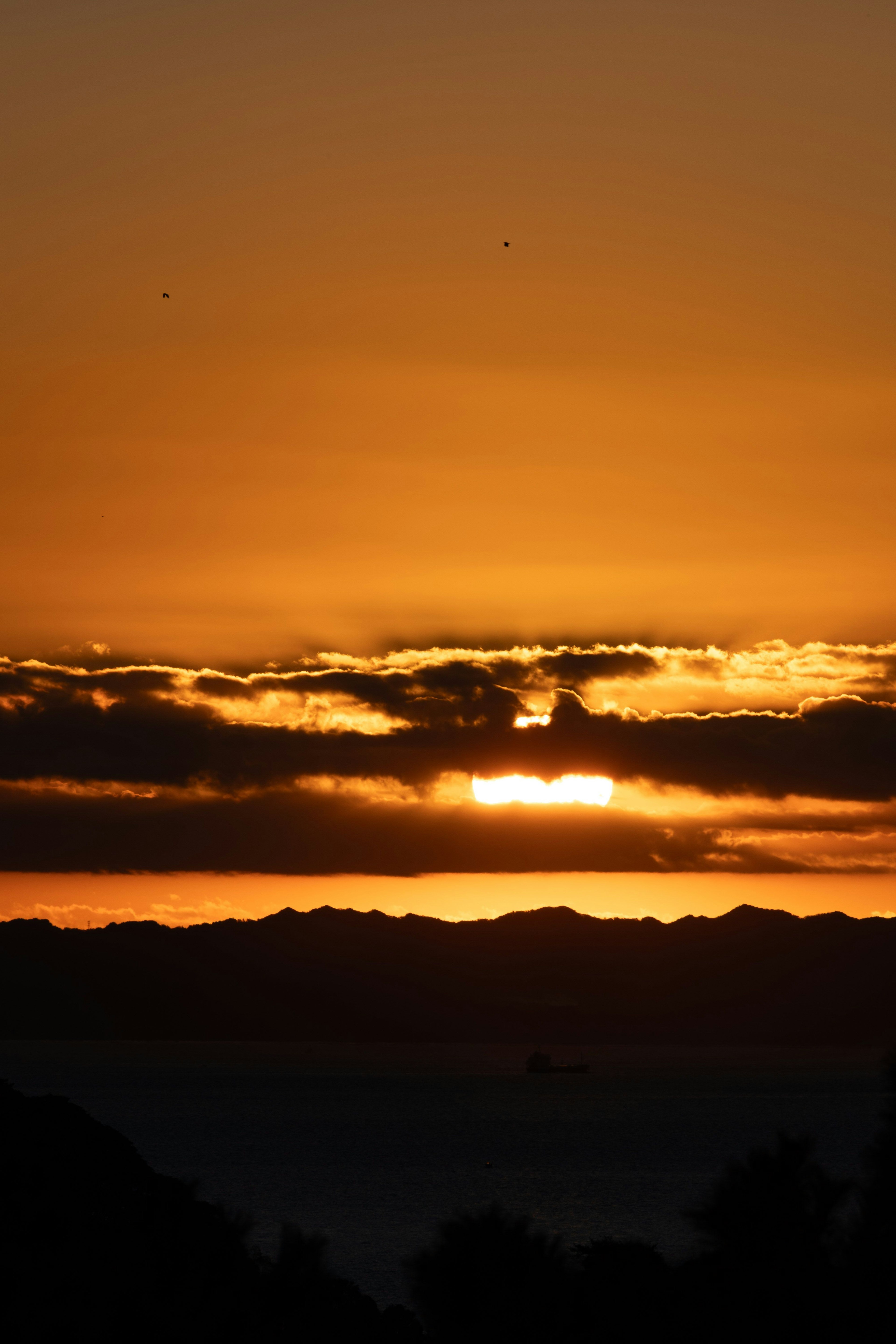 夕焼けの美しい景色、オレンジと黄色の空、雲の間からの太陽の光