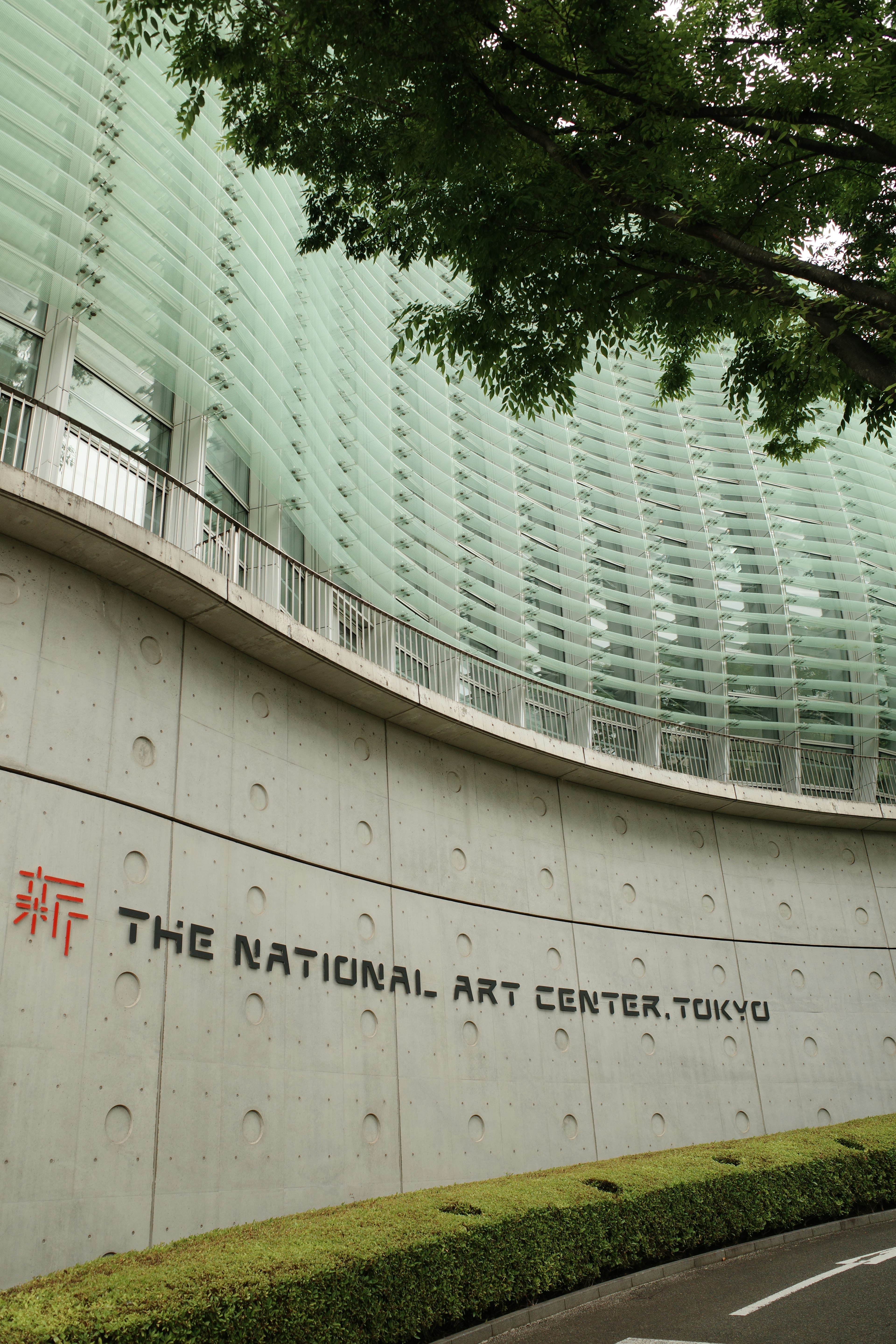 Exterior of The National Art Center Tokyo featuring green glass and concrete design