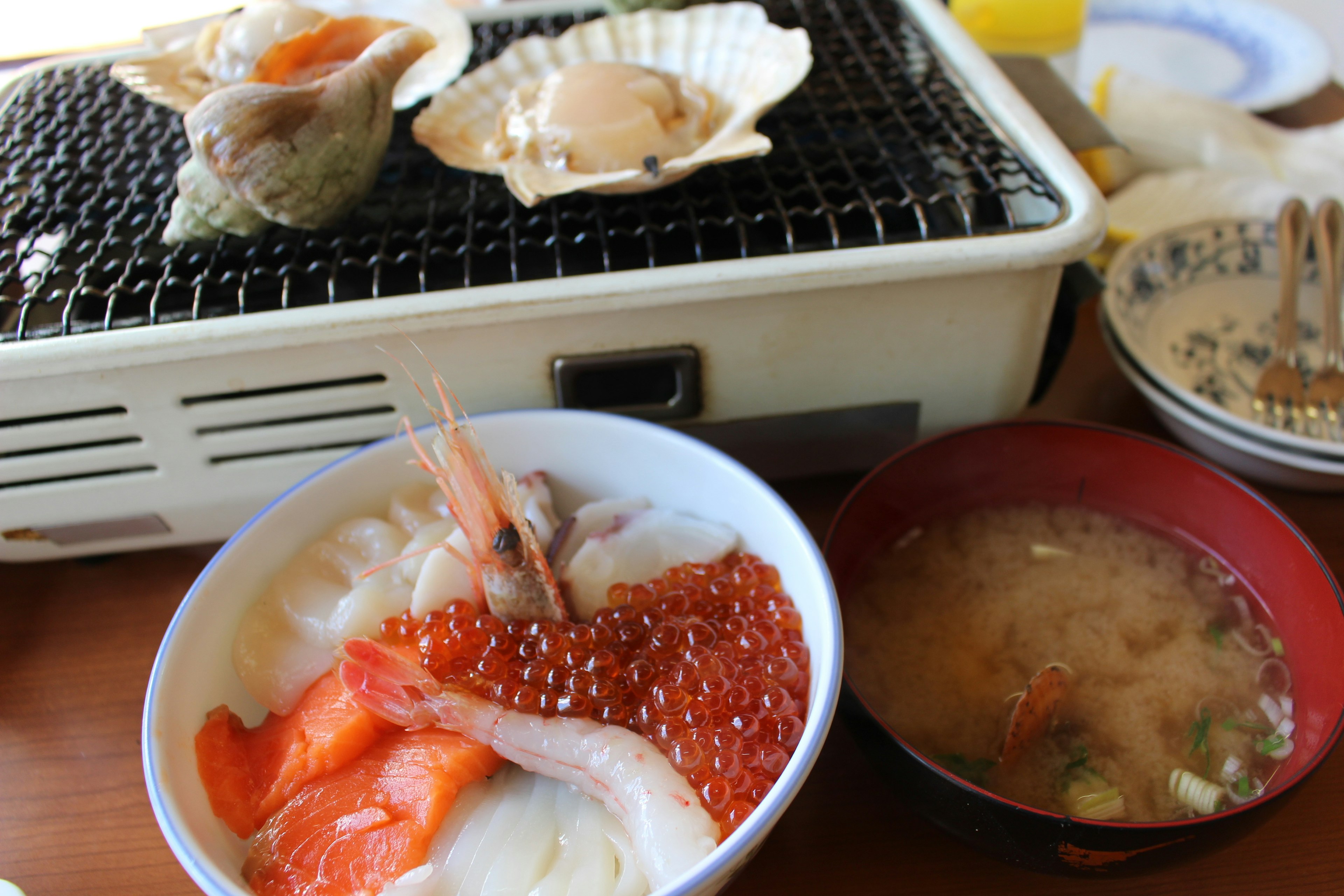 Scène de cuisine de fruits de mer japonais avec des coquillages grillés et du sashimi dans des bols