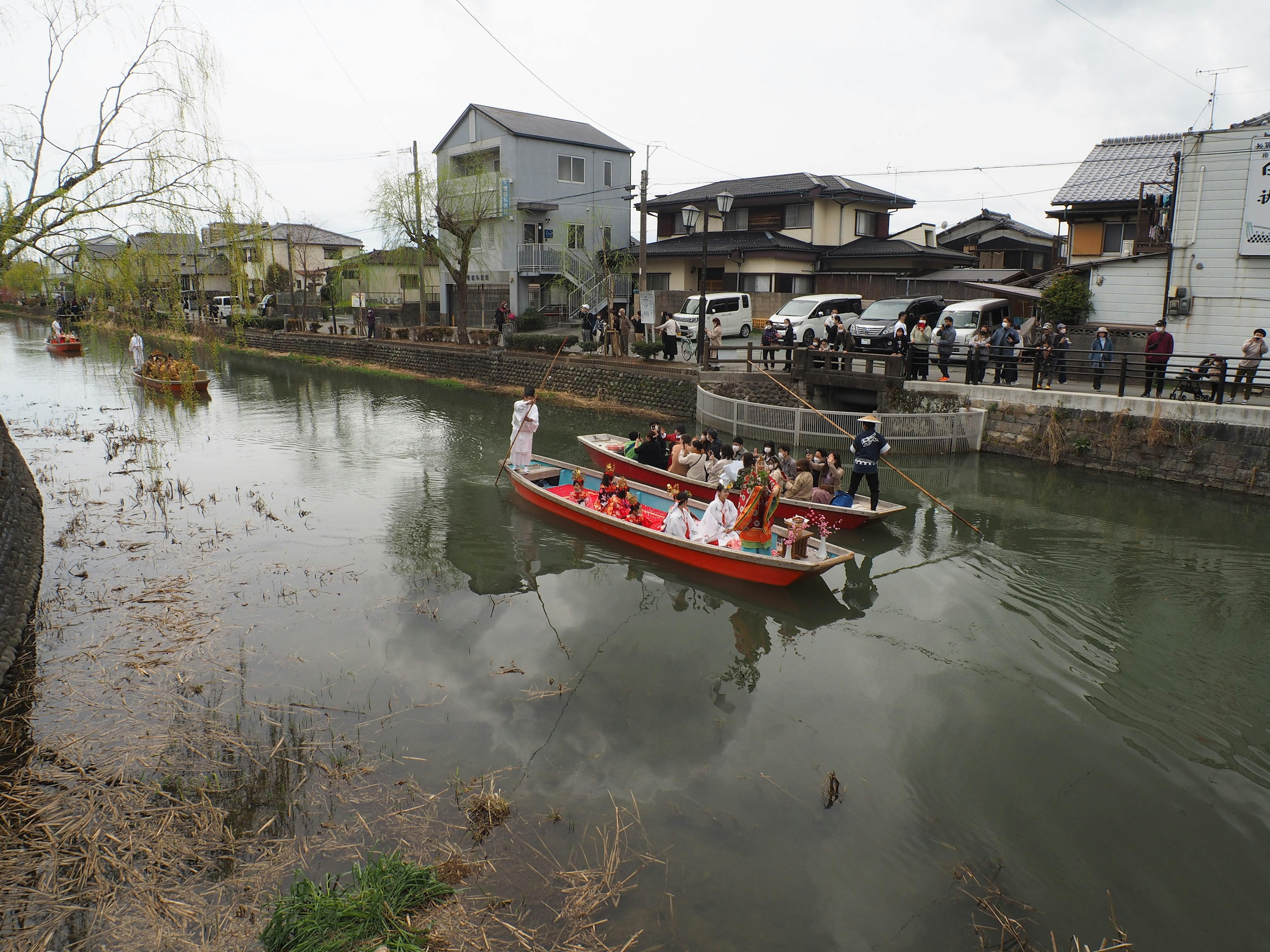 ผู้คนบนเรือท่องเที่ยวในแม่น้ำที่มีบ้านล้อมรอบ