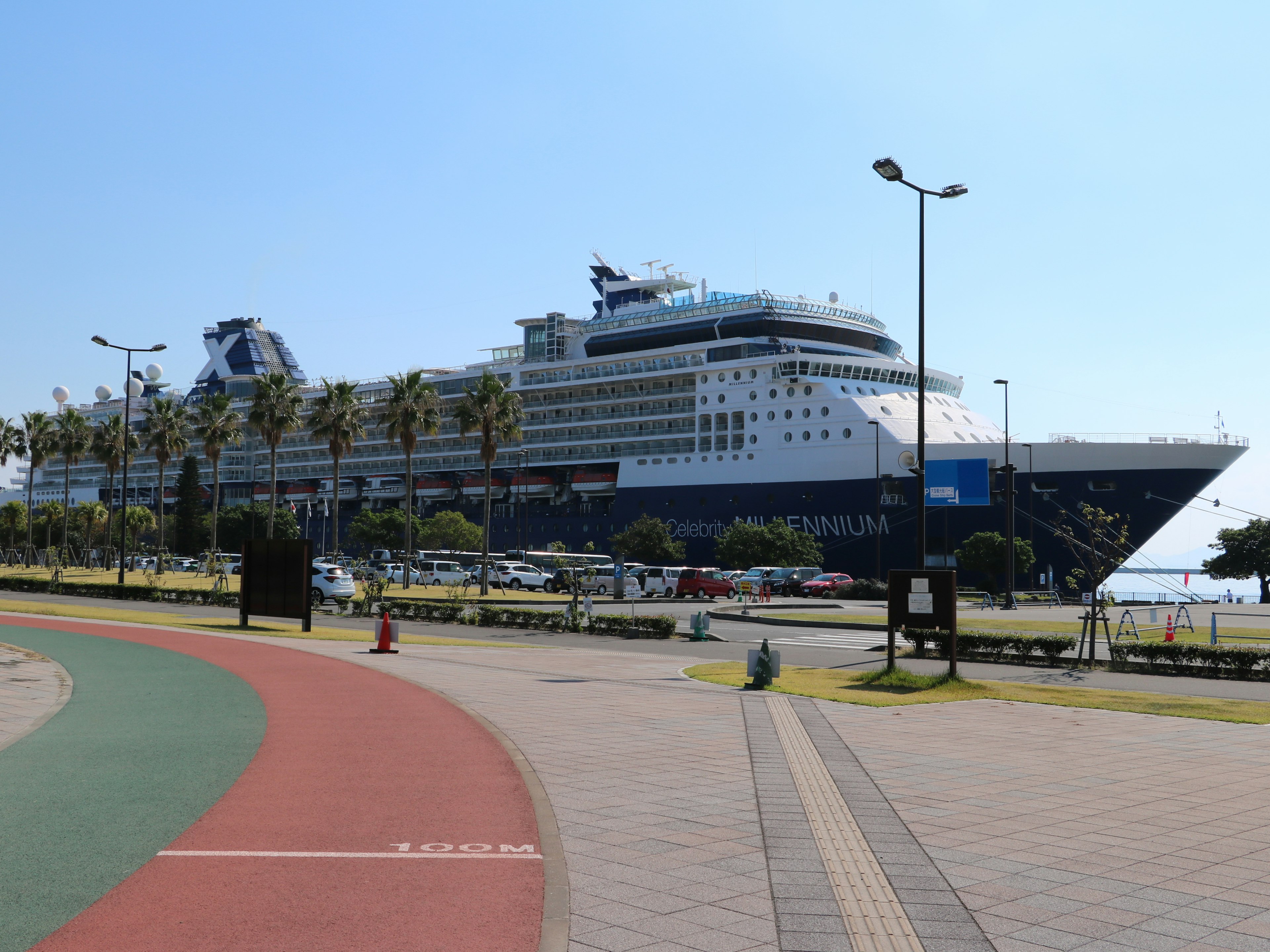 Un lujoso barco de crucero atracado en un puerto con palmeras alrededor